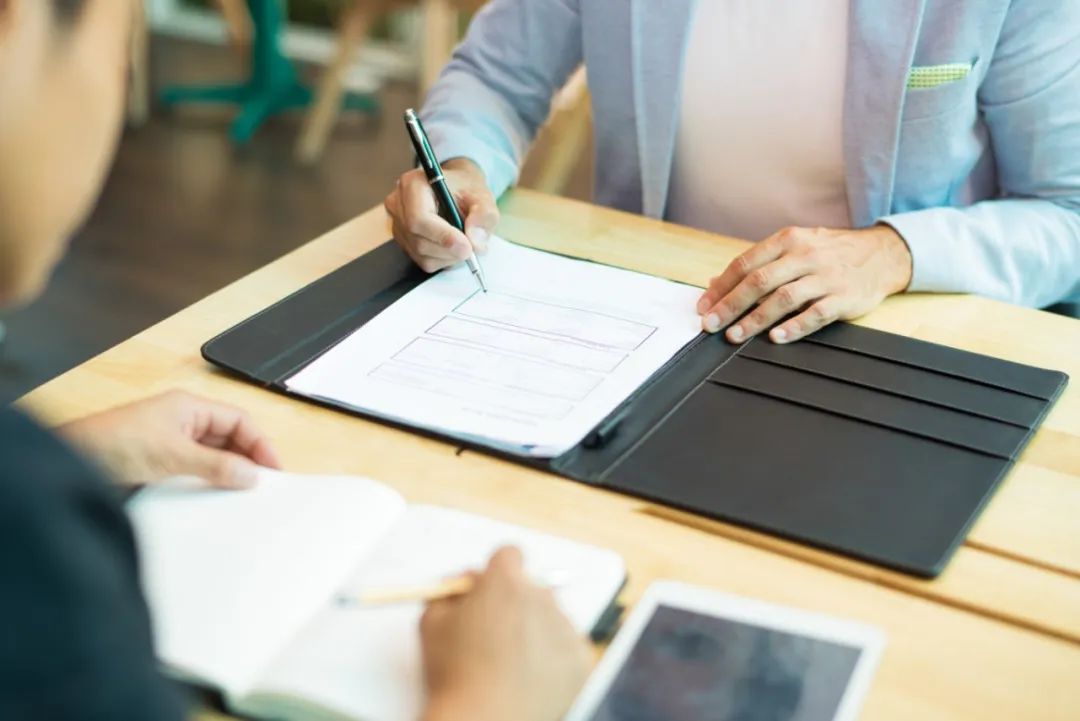 close-up-businessman-sitting-table-filling-document.jpg