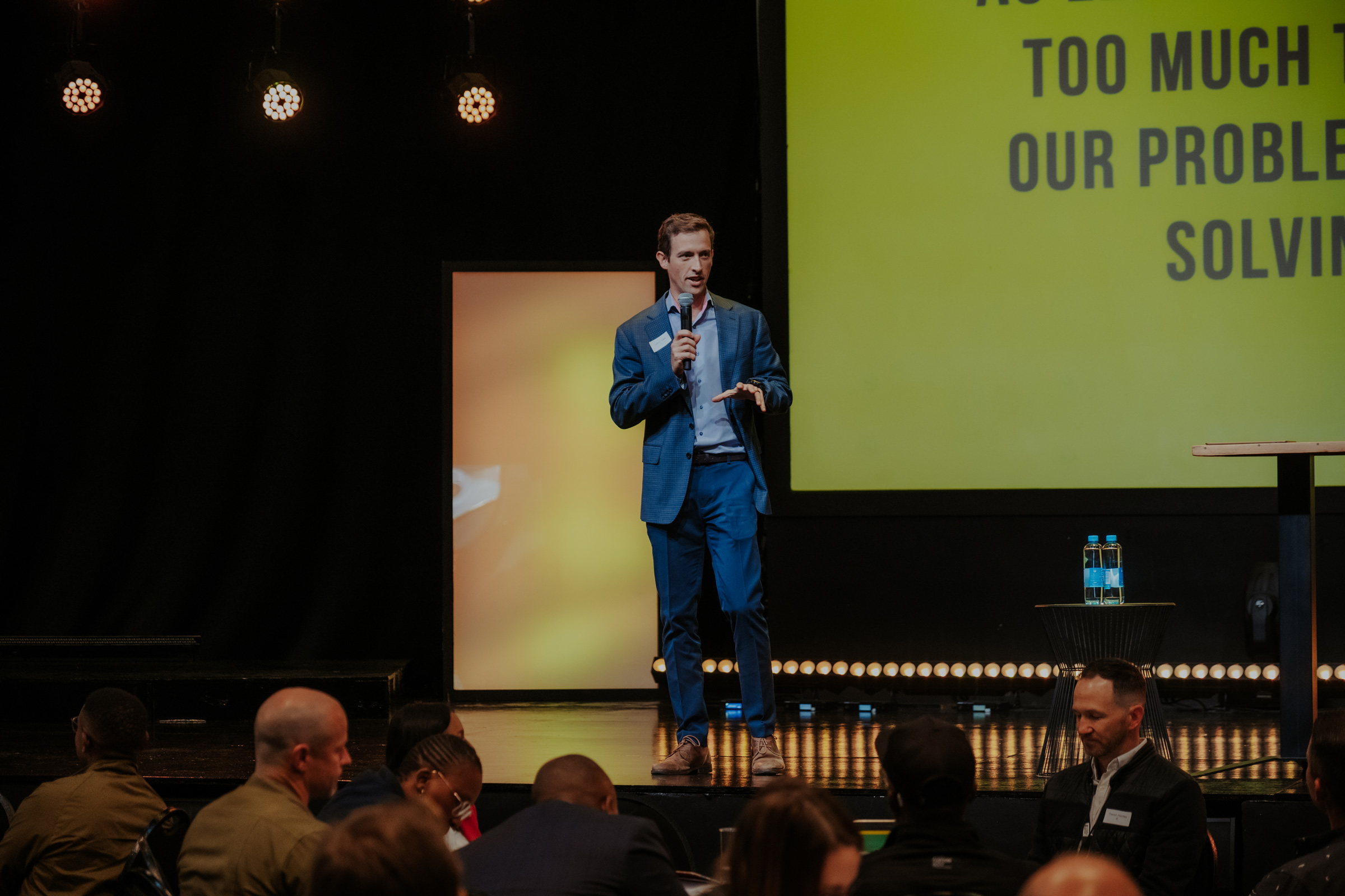 Man speaking on stage at a restory business event.