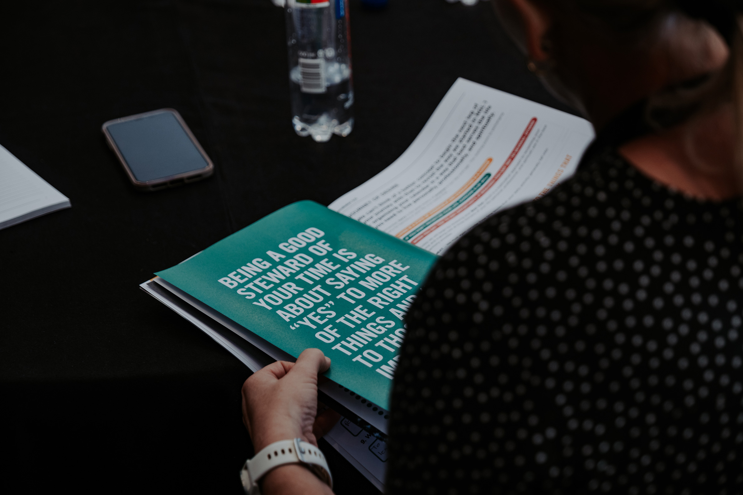 Person reading a restory business workbook during a session.