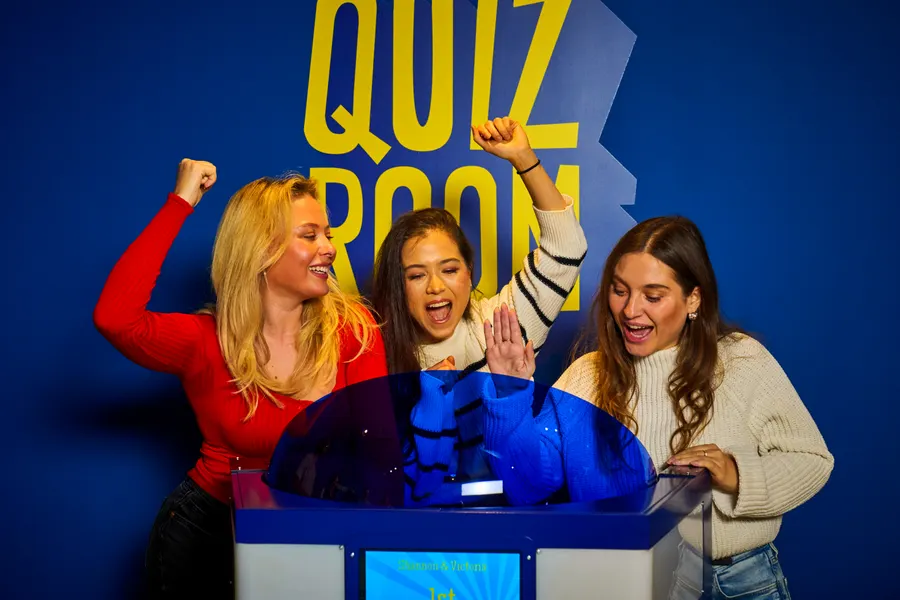 Deelnemers spelen quiz spel samen in Roosdaal zaal