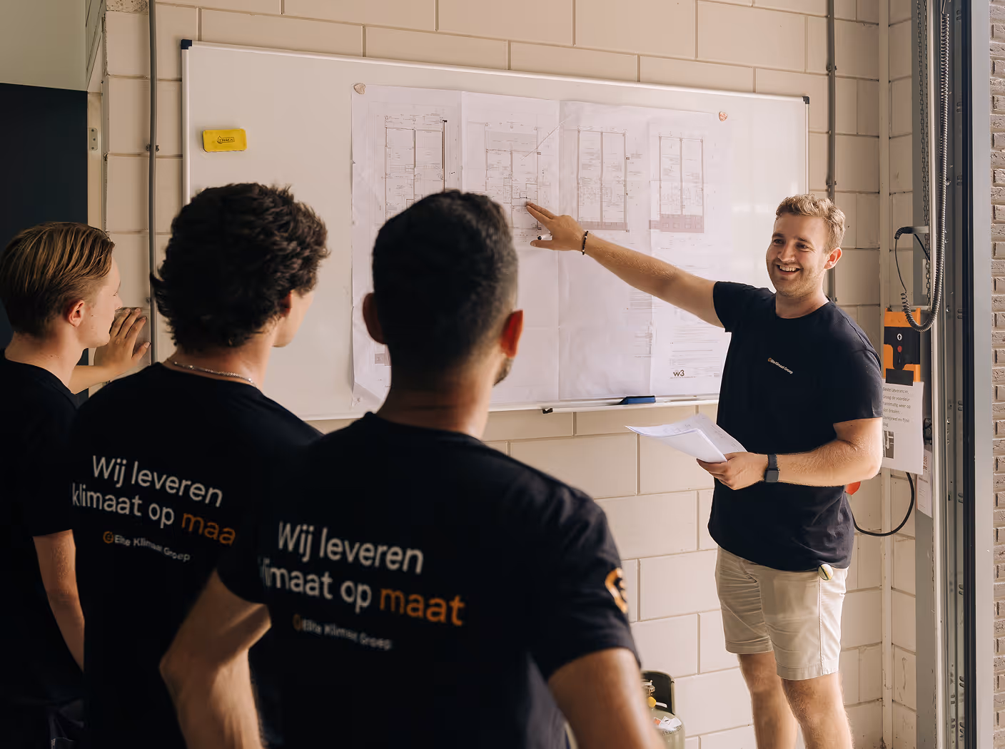 Installateurs luisteren naar de uitleg over de plaatsing van een duurzame installatie.