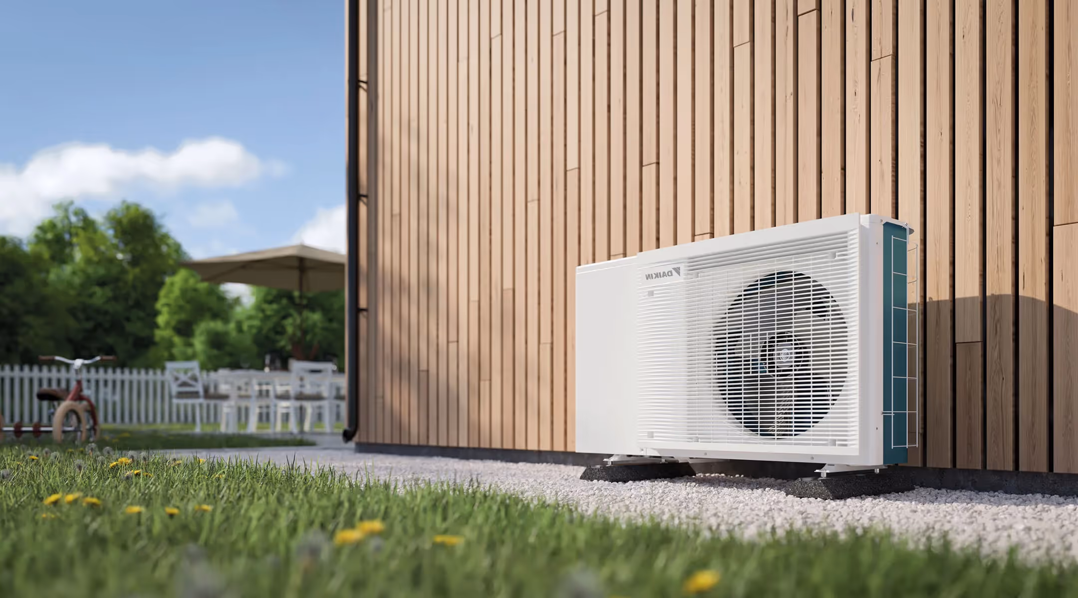 Buitenunit van een warmtepomp naast een houten gevel in een groene tuin.