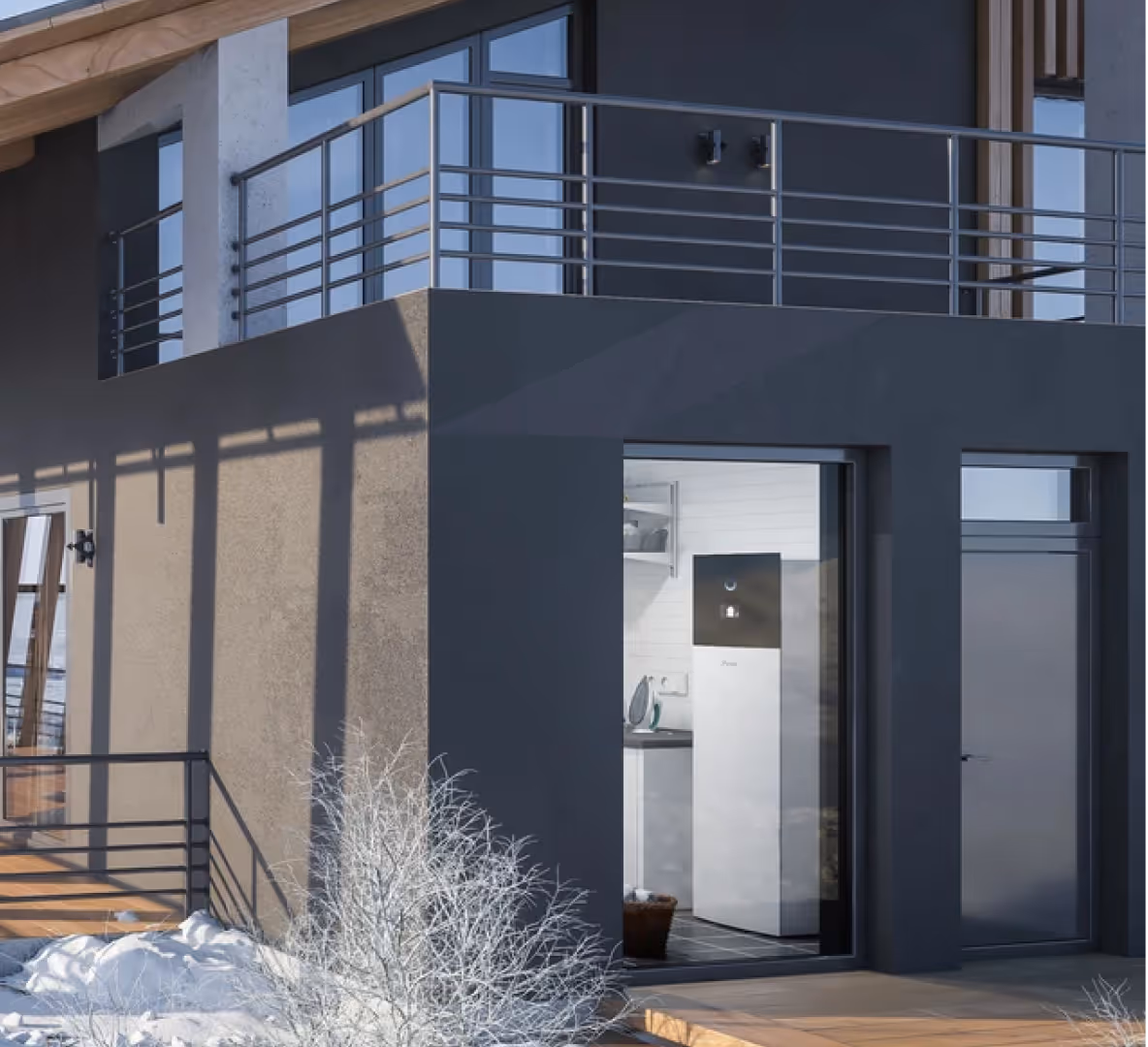 Warmtepomp zichtbaar door een raam van een moderne woning in winterse omstandigheden.