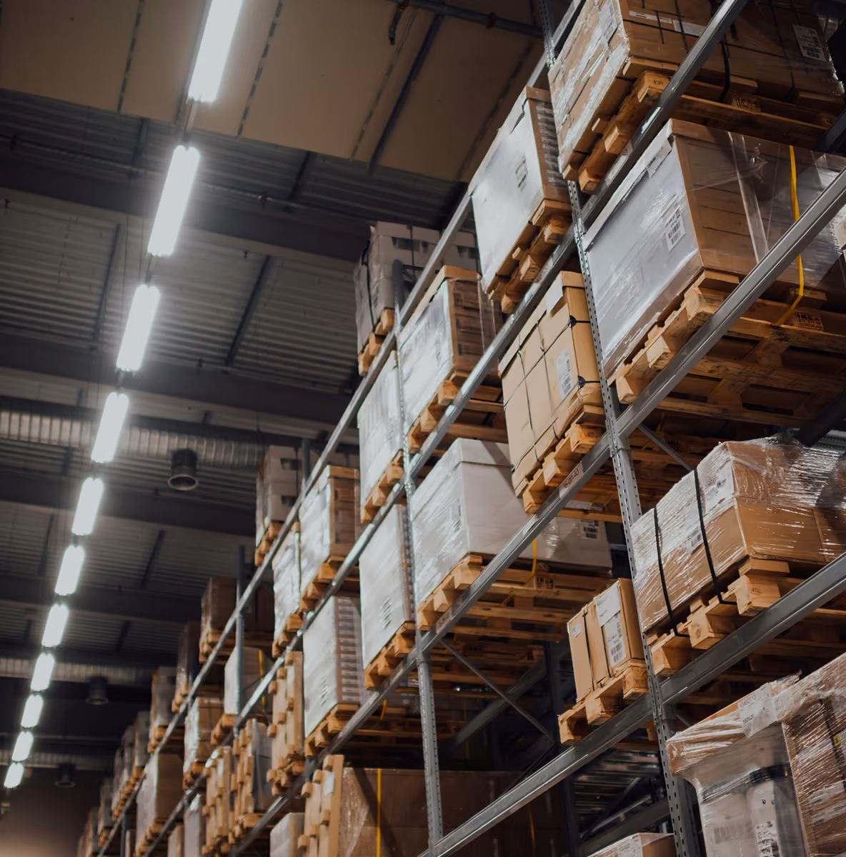 Hoge magazijnstellingen vol met pallets en dozen in een logistiek distributiecentrum