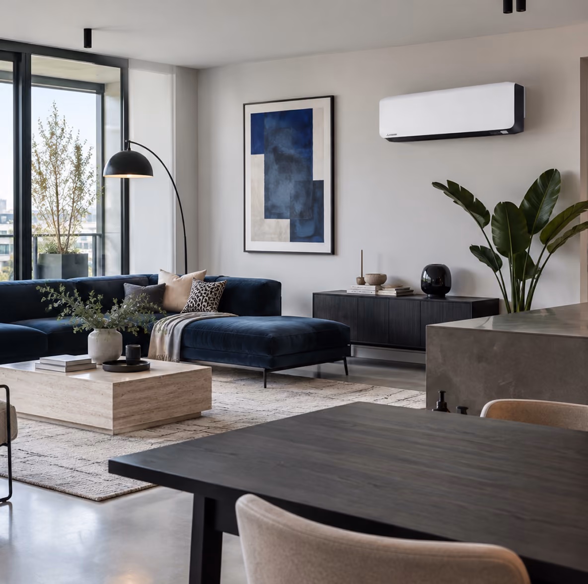 Mitsubishi Diamond Series airco in een moderne woonkamer met donkerblauwe hoekbank en travertin salontafel