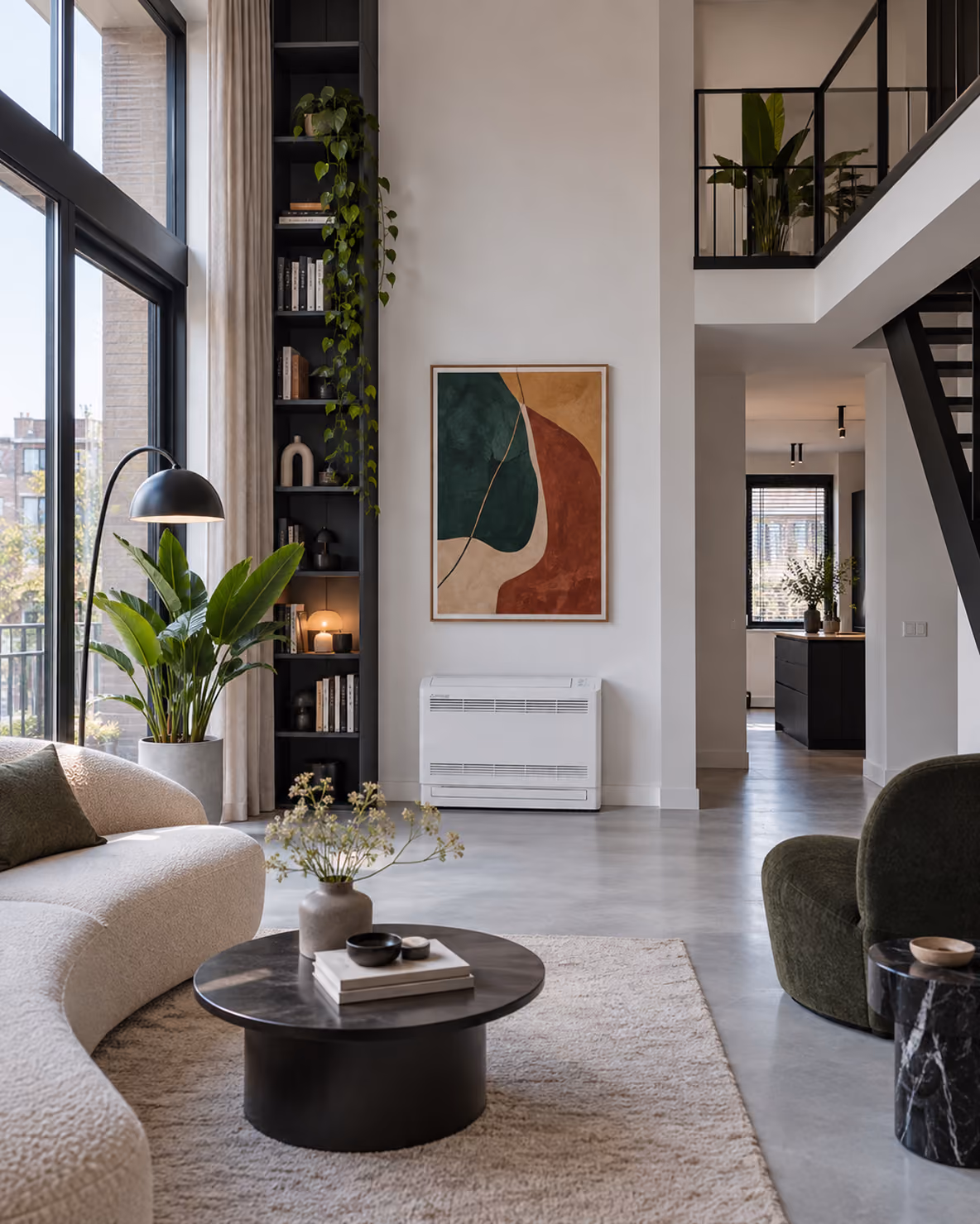 Mitsubishi vloermodel airco laag aan de wand onder een abstract schilderij in een loft met vide en ronde bank