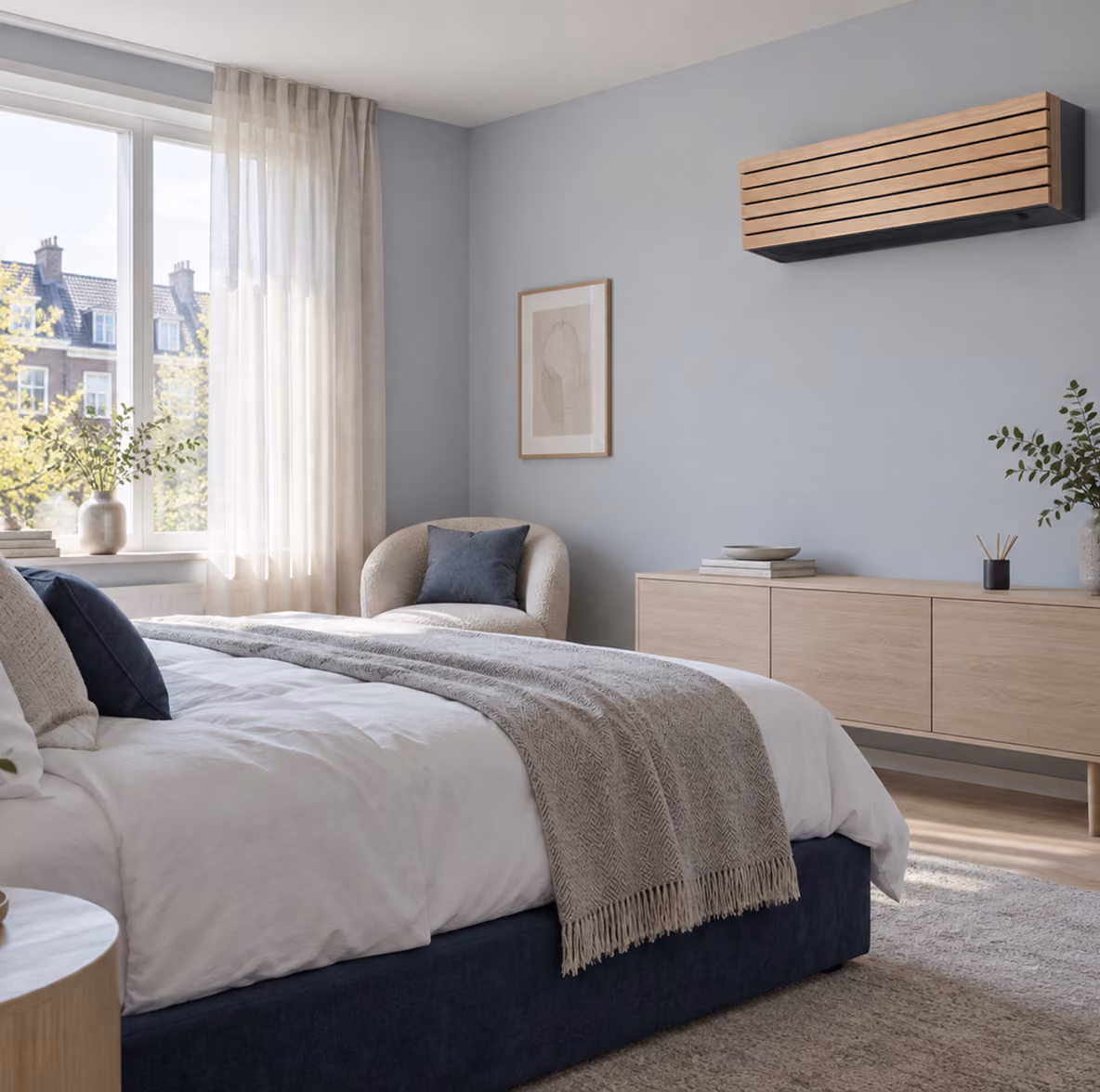 Toshiba Daiseikai airco met houten lamellenfront op een lichtblauwe wand in een slaapkamer met donkerblauw bed