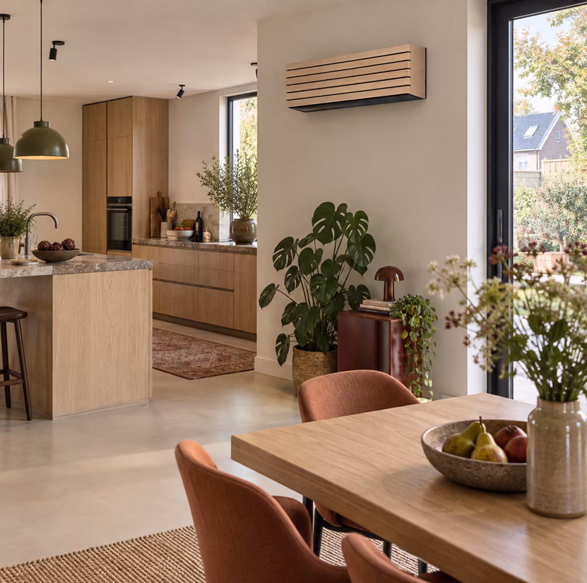 Toshiba Daiseikai airco met houten lamellenfront in een open keuken met eiken kastenwand en eettafel