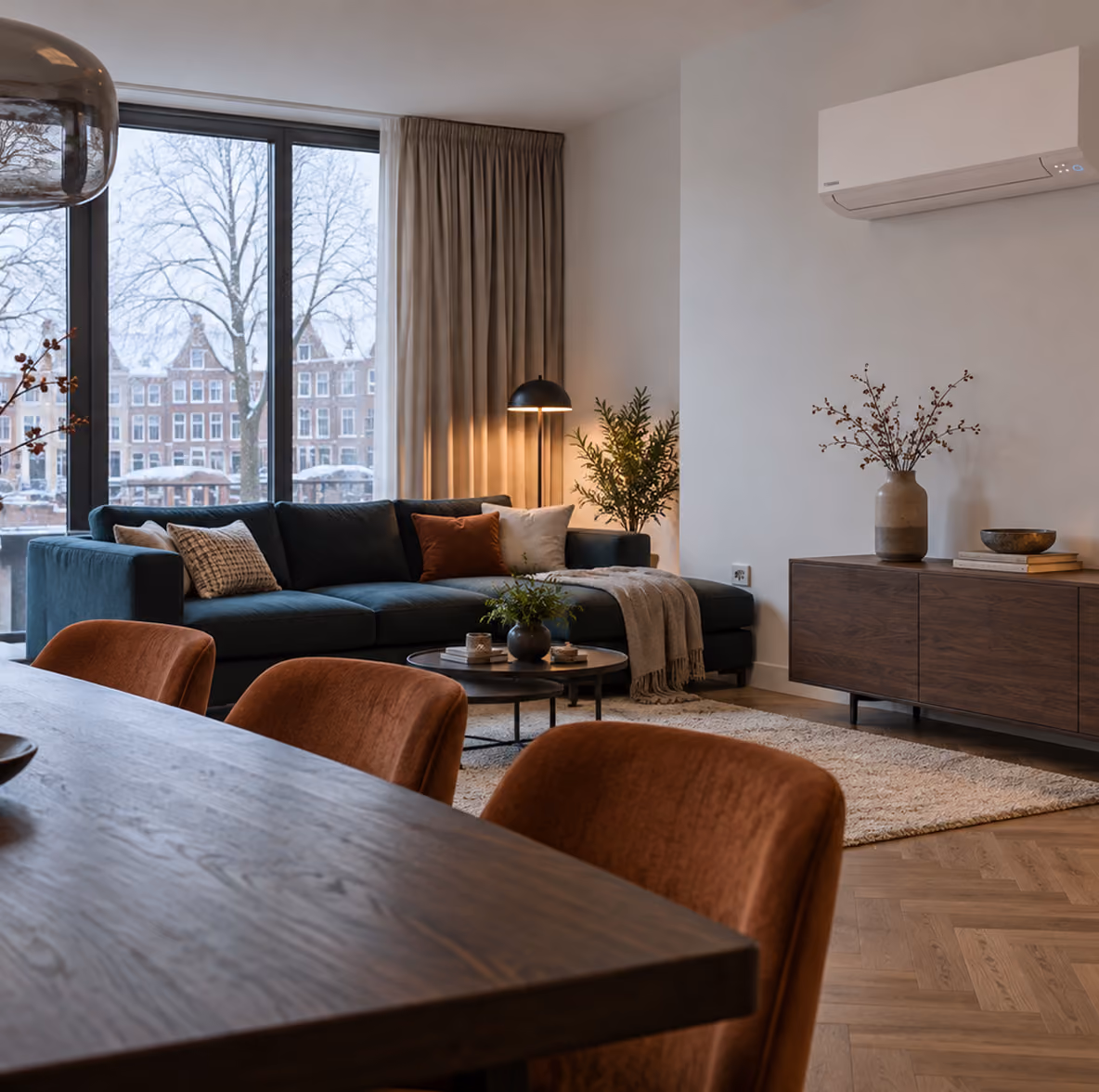 Toshiba Kazumi airco in een warme woonkamer op een winterdag met blauwe bank en uitzicht op grachtenpanden