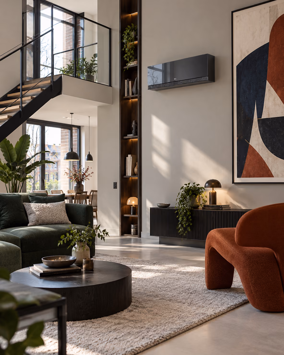 LG AI Air Mirror airco in een loft met zwarte trap, groene bank en terracotta fauteuil