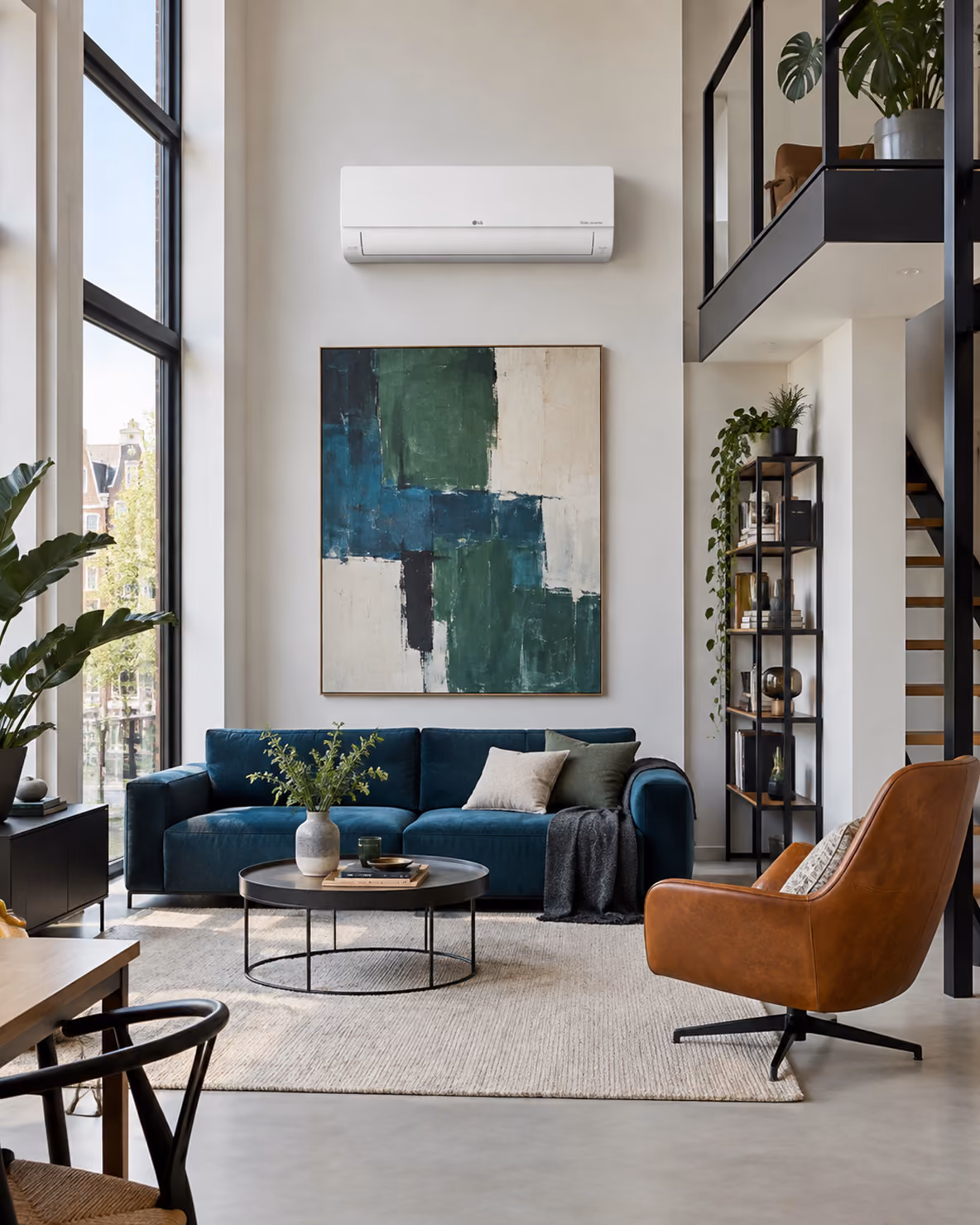 LG Standard Plus airco boven een abstract schilderij in een loft met blauwe bank en leren fauteuil