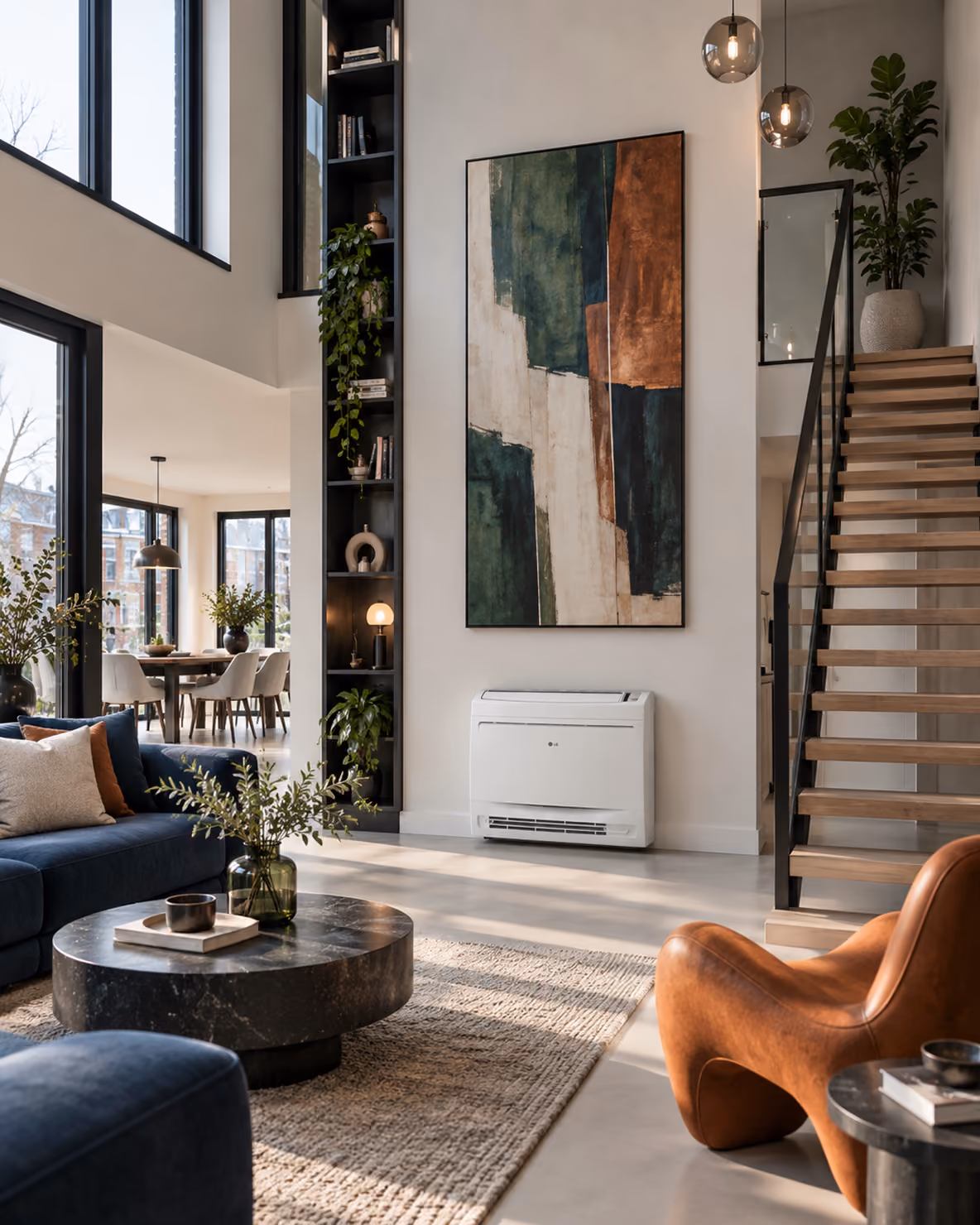 LG vloermodel airco laag aan de wand onder een abstract schilderij in een loft met houten trap en blauwe bank