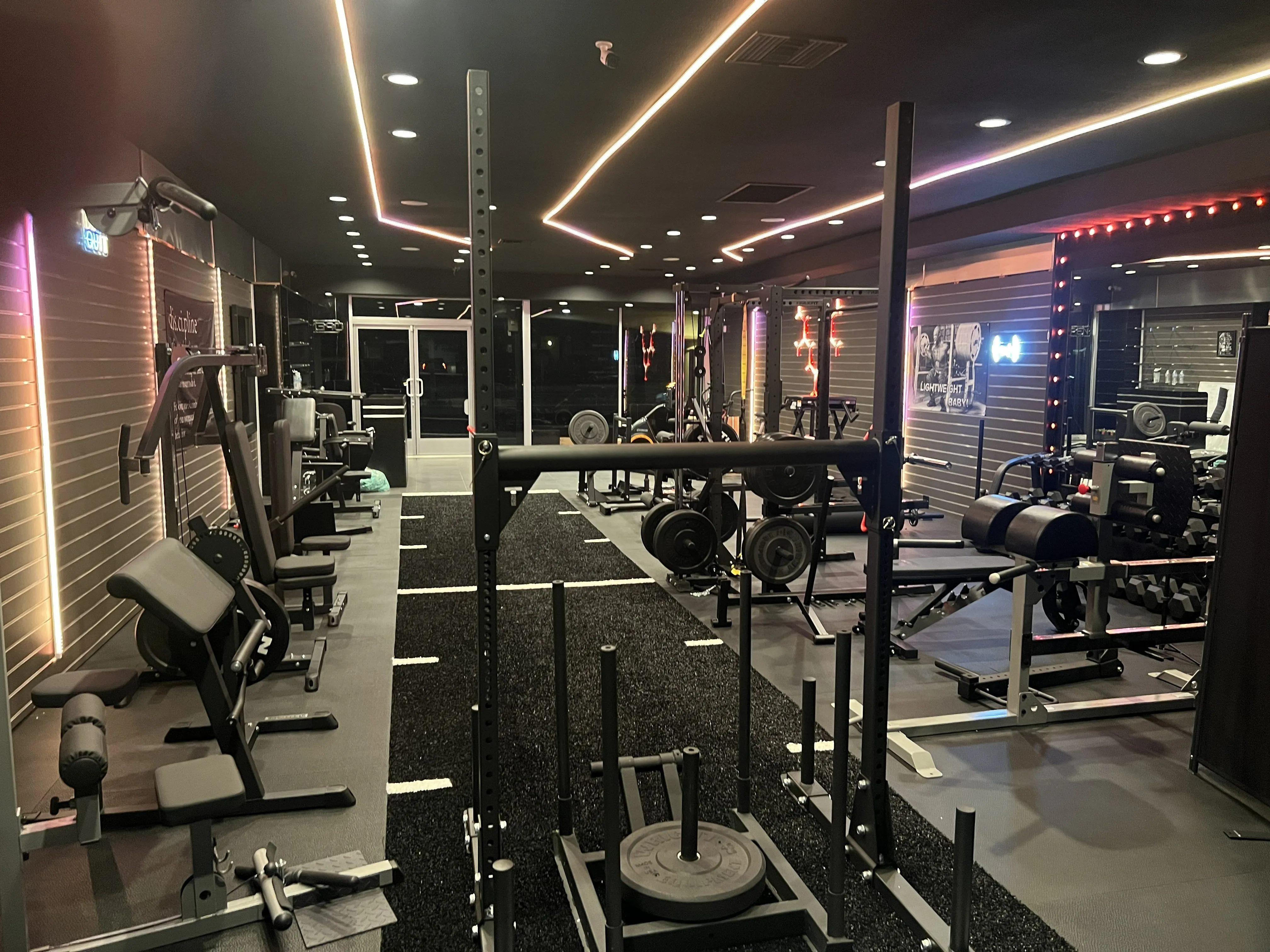 Interior of Thrive Strength & Performance, a private one-on-one training studio in Costa Mesa, with squat racks, dumbbells and a sled.