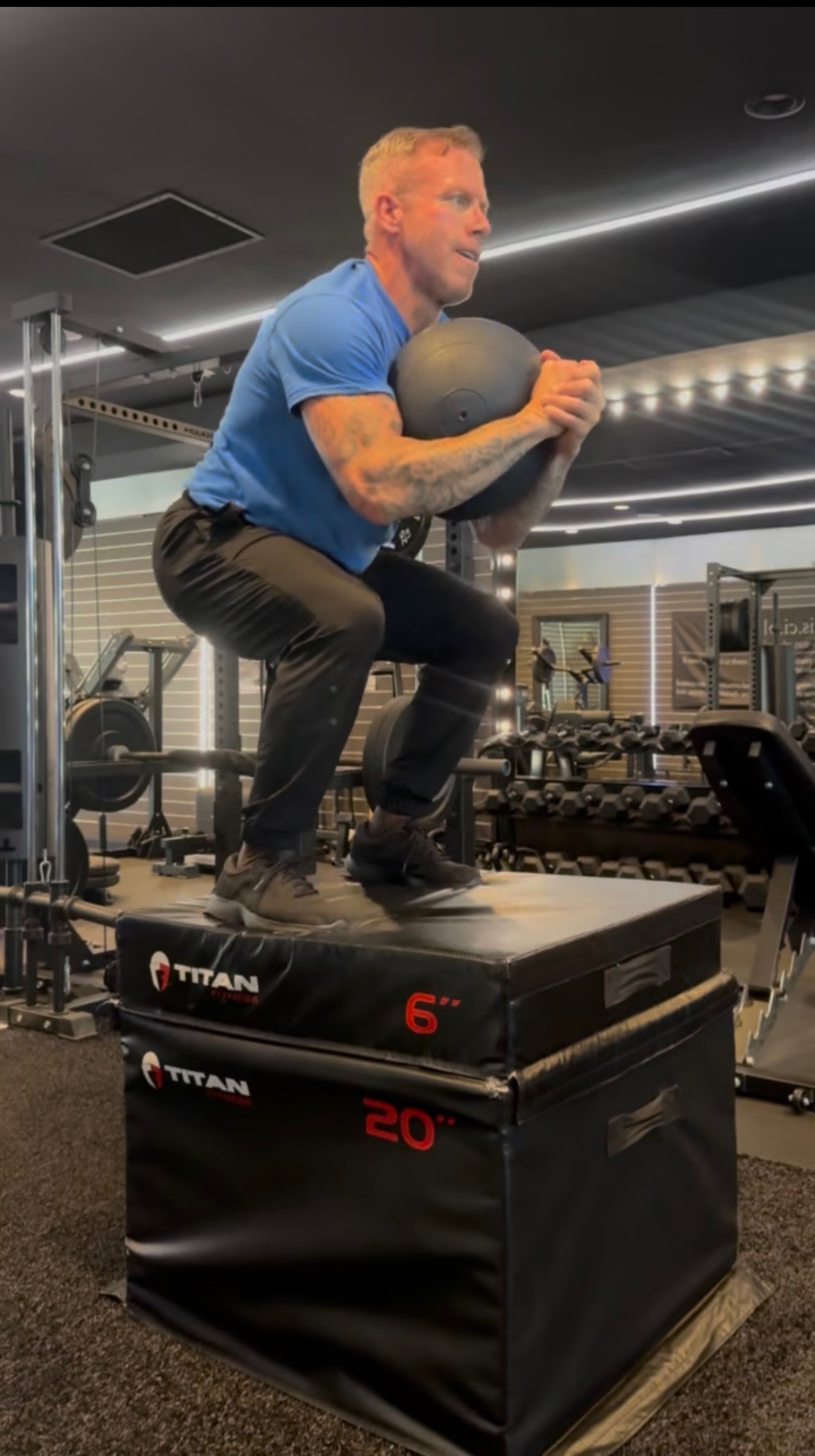Client training power with a box jump and medicine ball in Costa Mesa