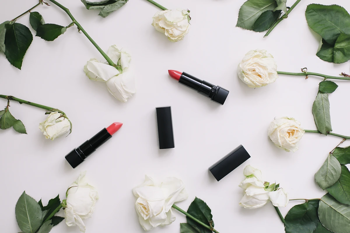 The best bridal lipsticks displayed together with beautiful white flowers.