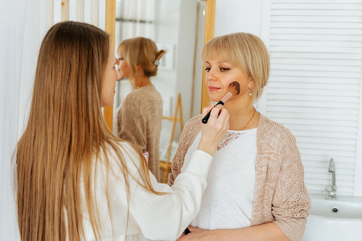 Makeup artist and radiant mother of the bride over 60 with soft glowing makeup.