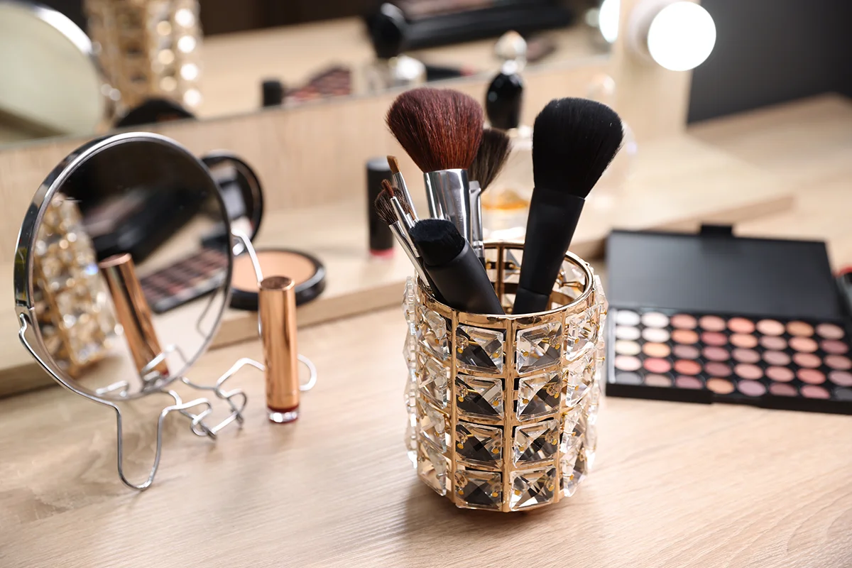 Professional makeup replacement brushes in a crystal gold cup.