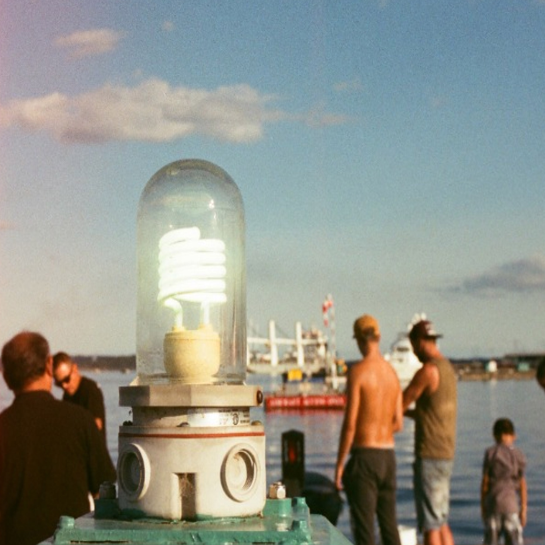 Peoplat at shore with a huge light bulb