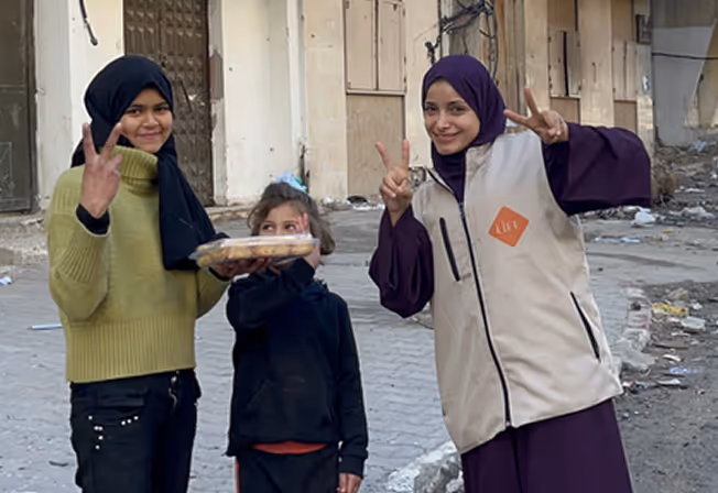 Bénévole LIFE et enfants gazaouis dans les décombres en palestine. Faire un don pour gaza