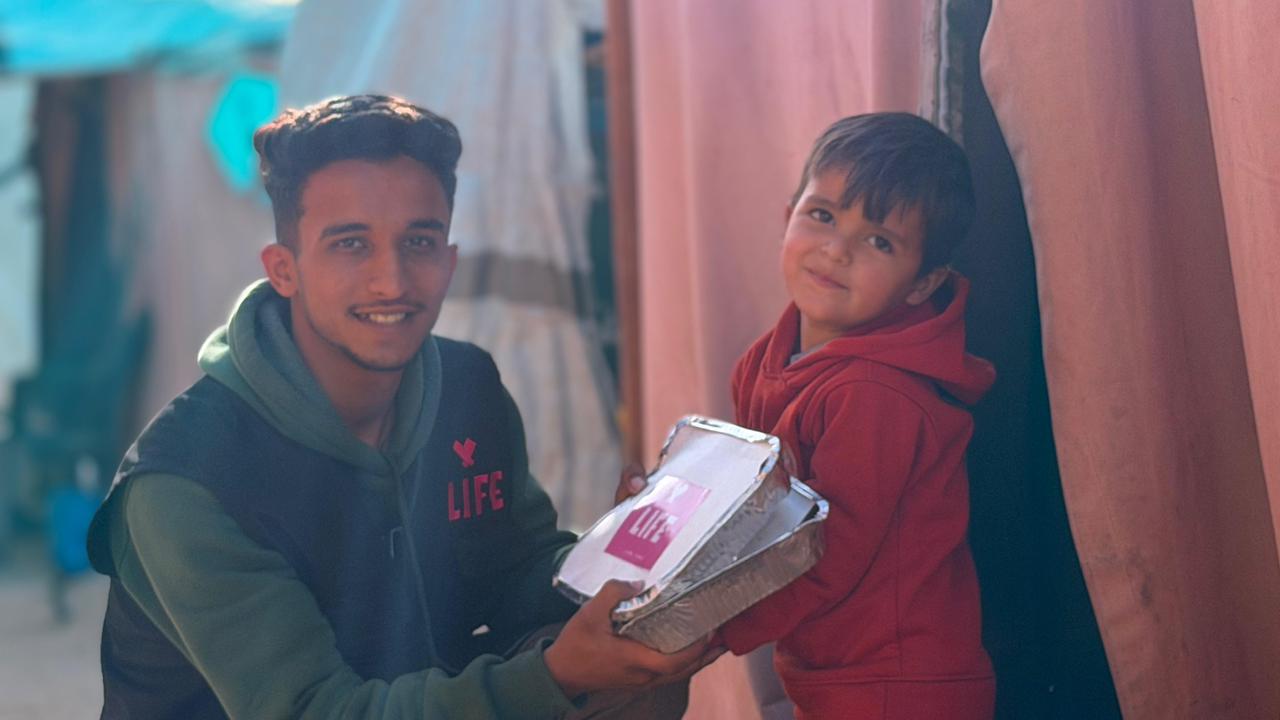 Bénévole LIFE remettant un repas à un enfant à Gaza