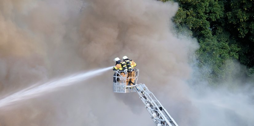 Pompiers luttant contre un feu de forêt dans la fumée