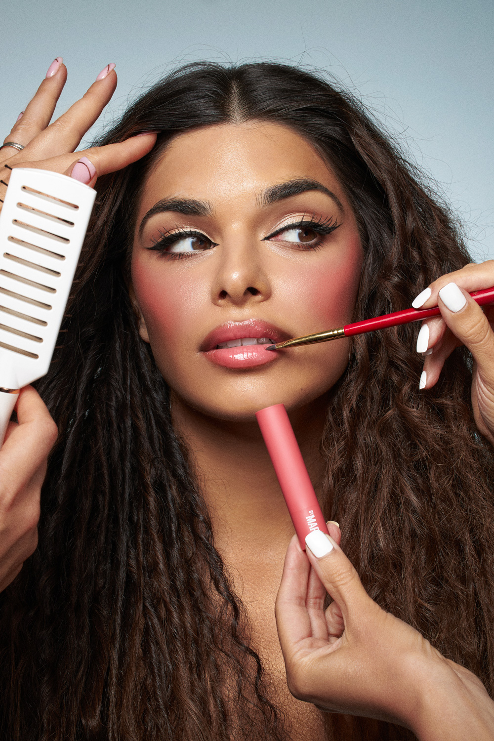 A woman with a pink brush in her hand.