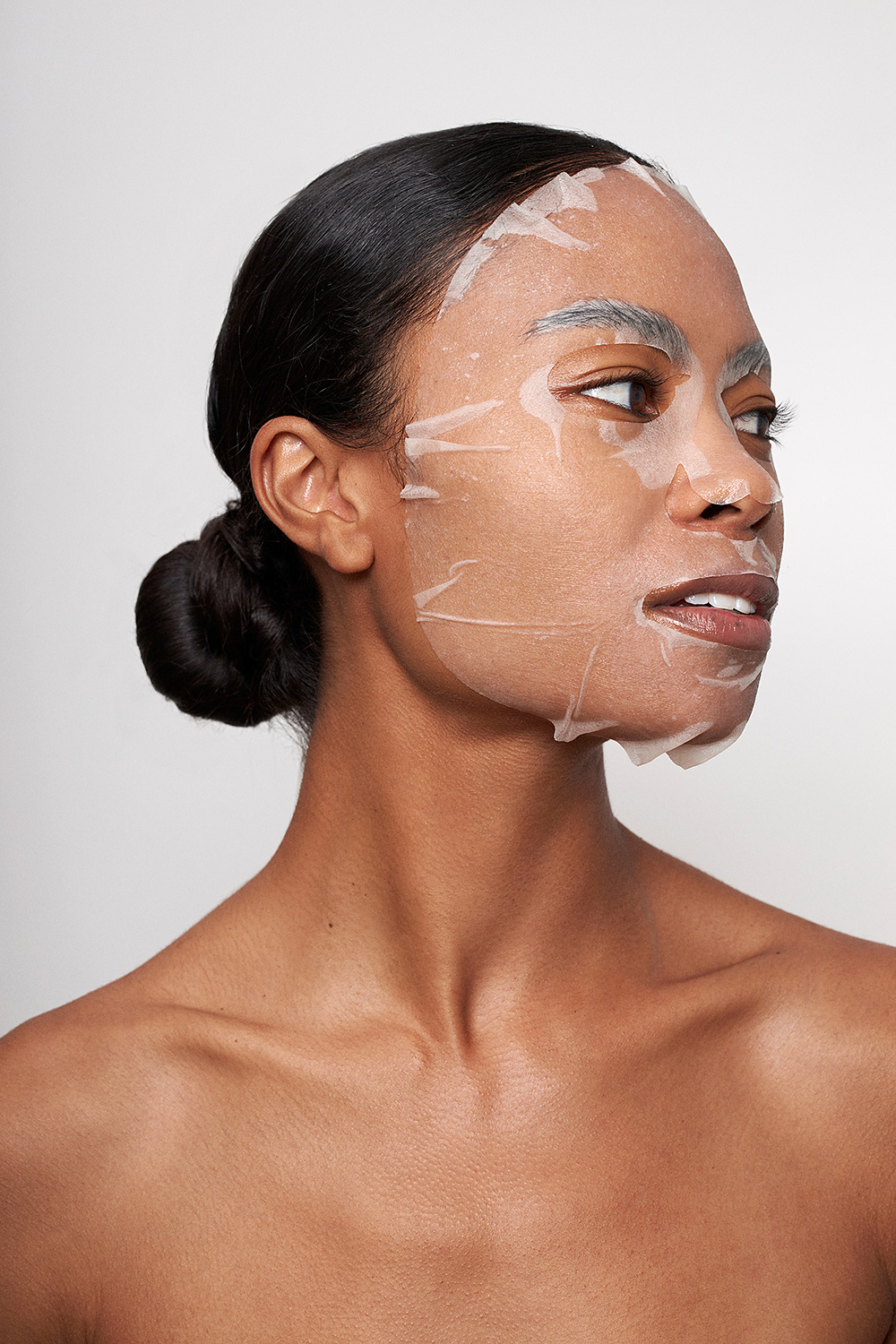 A woman with a sheetmask on her face.