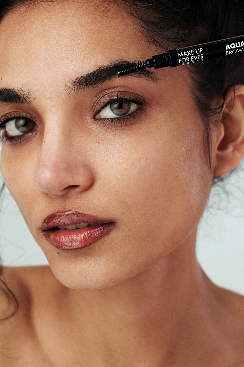 A woman with a ponytail and lipstick on her lips.