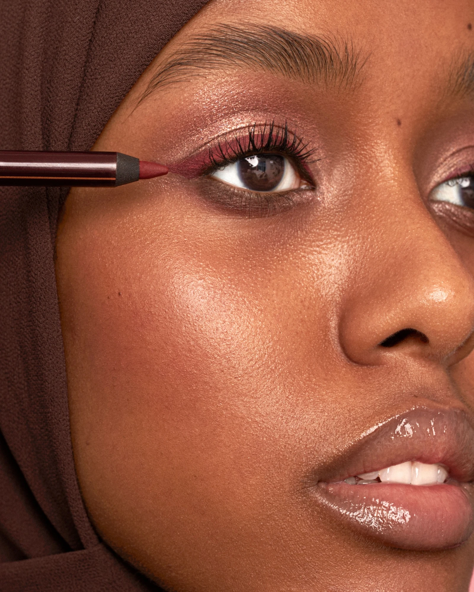 A woman with brown eyes and a brown head scarf.