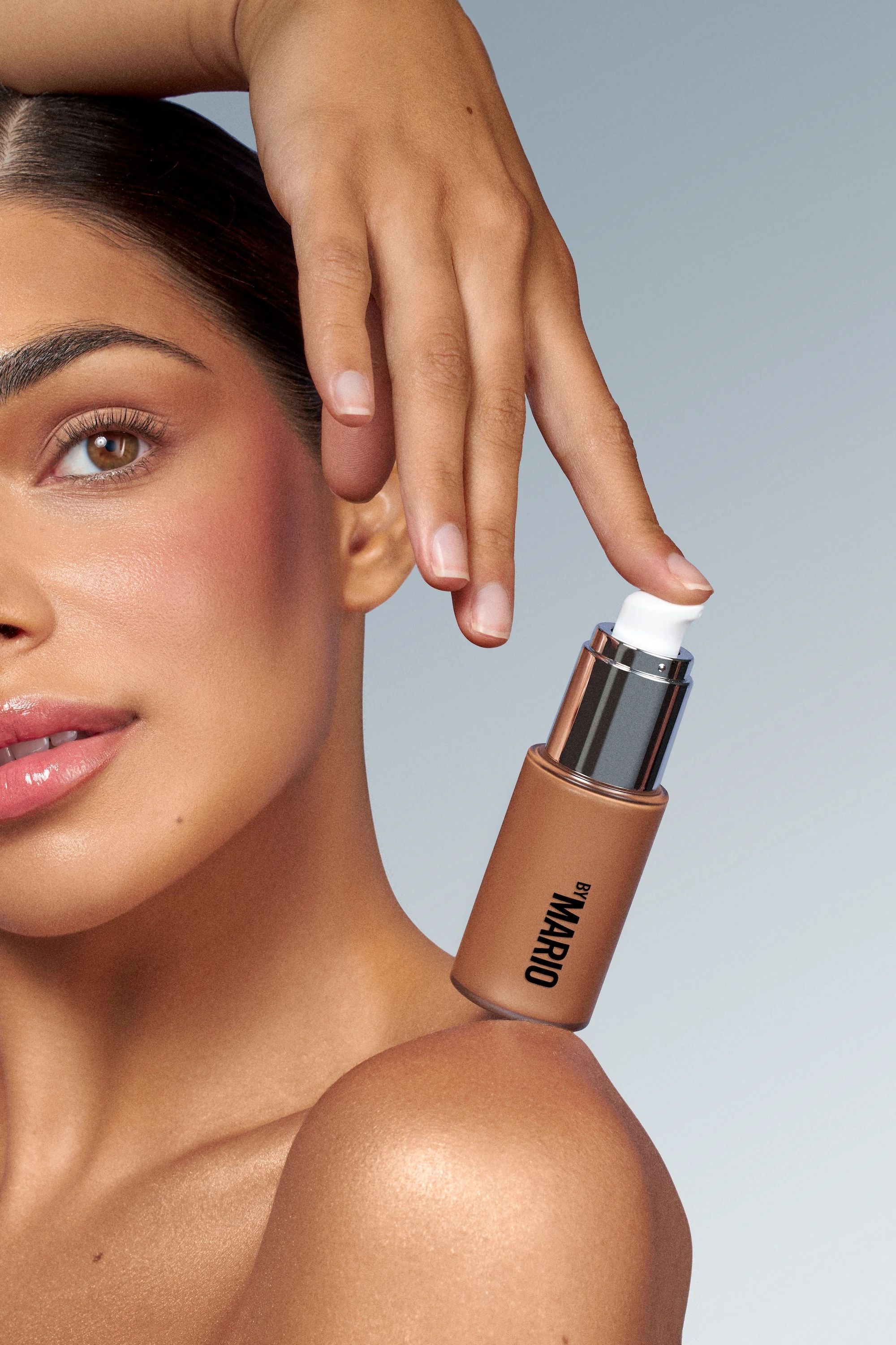 A woman with a brown bottle of lotion on her shoulder.