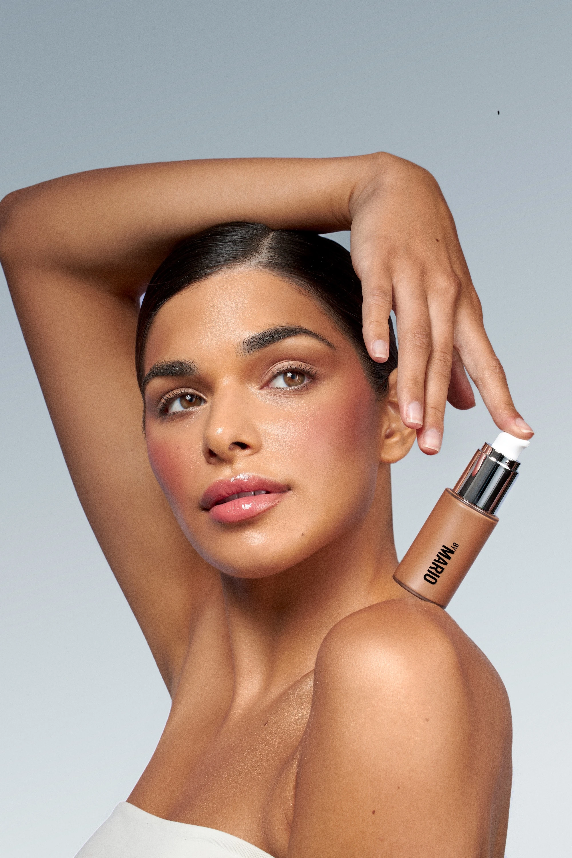 A woman with a brown bottle of makeup on her shoulder.