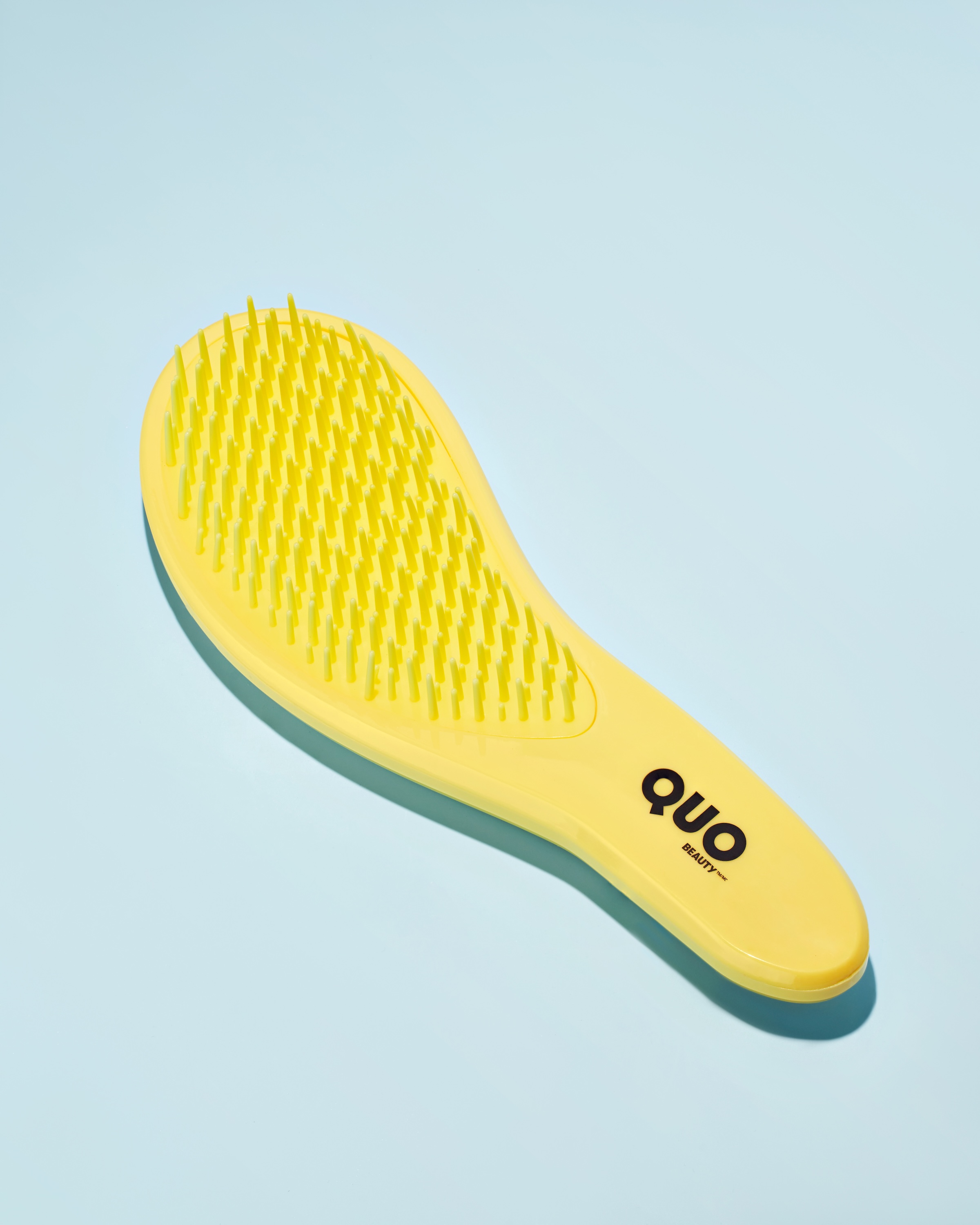 A yellow comb with a black logo on it.