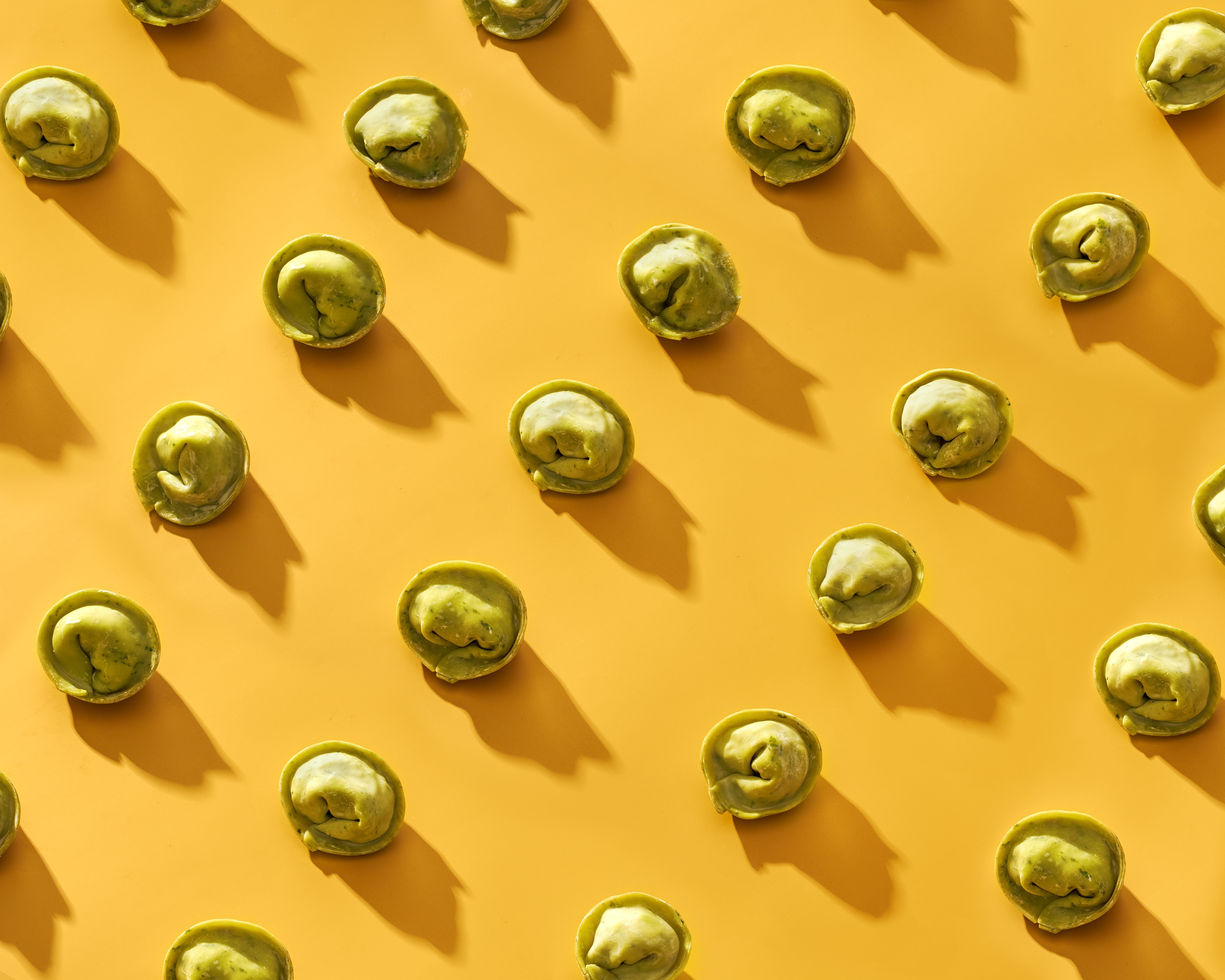 A yellow background with green and brown food items.