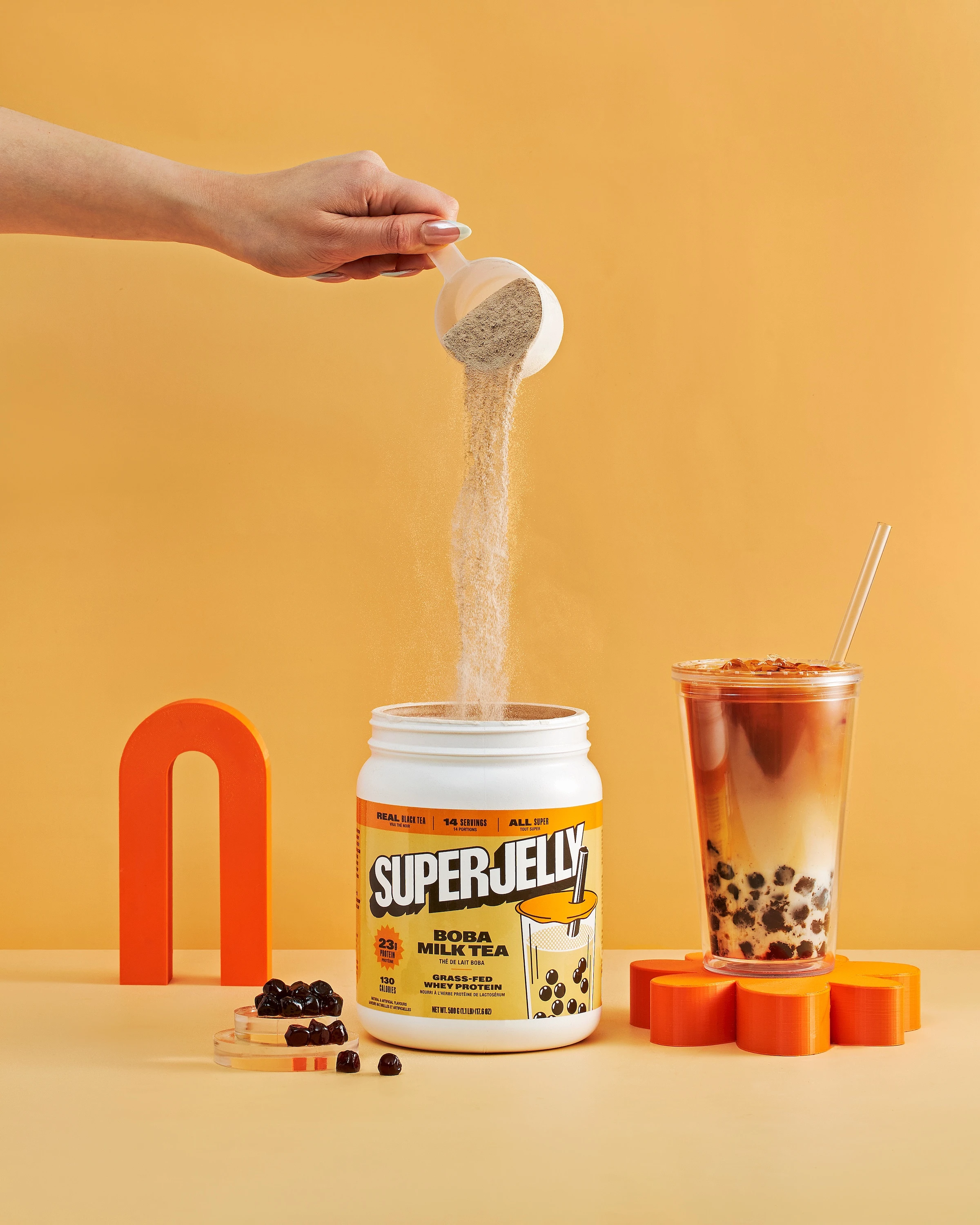A container of Super Jelly is being poured into a glass.