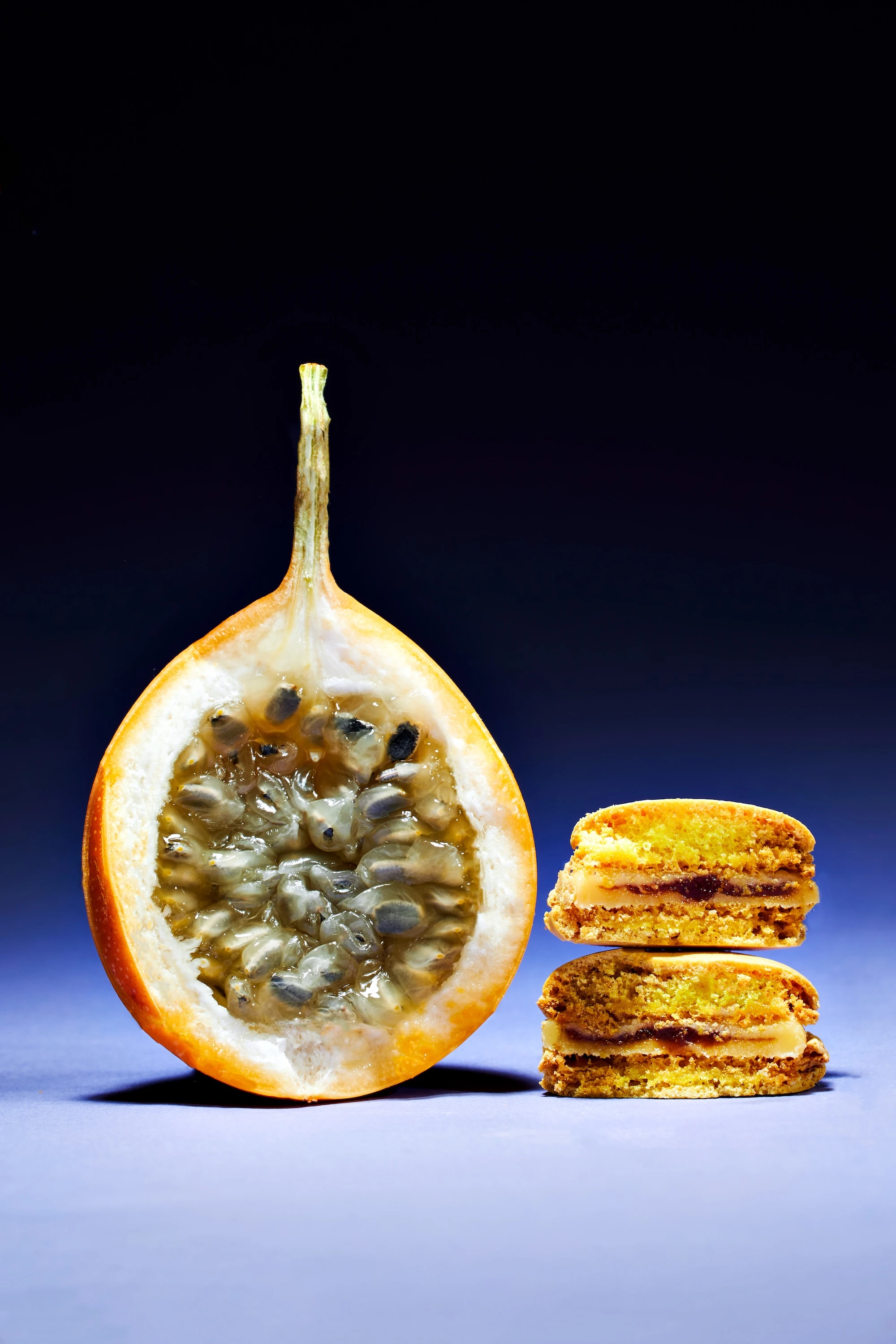 A slice of bread with a sandwich on top and a fruit with seeds in it.