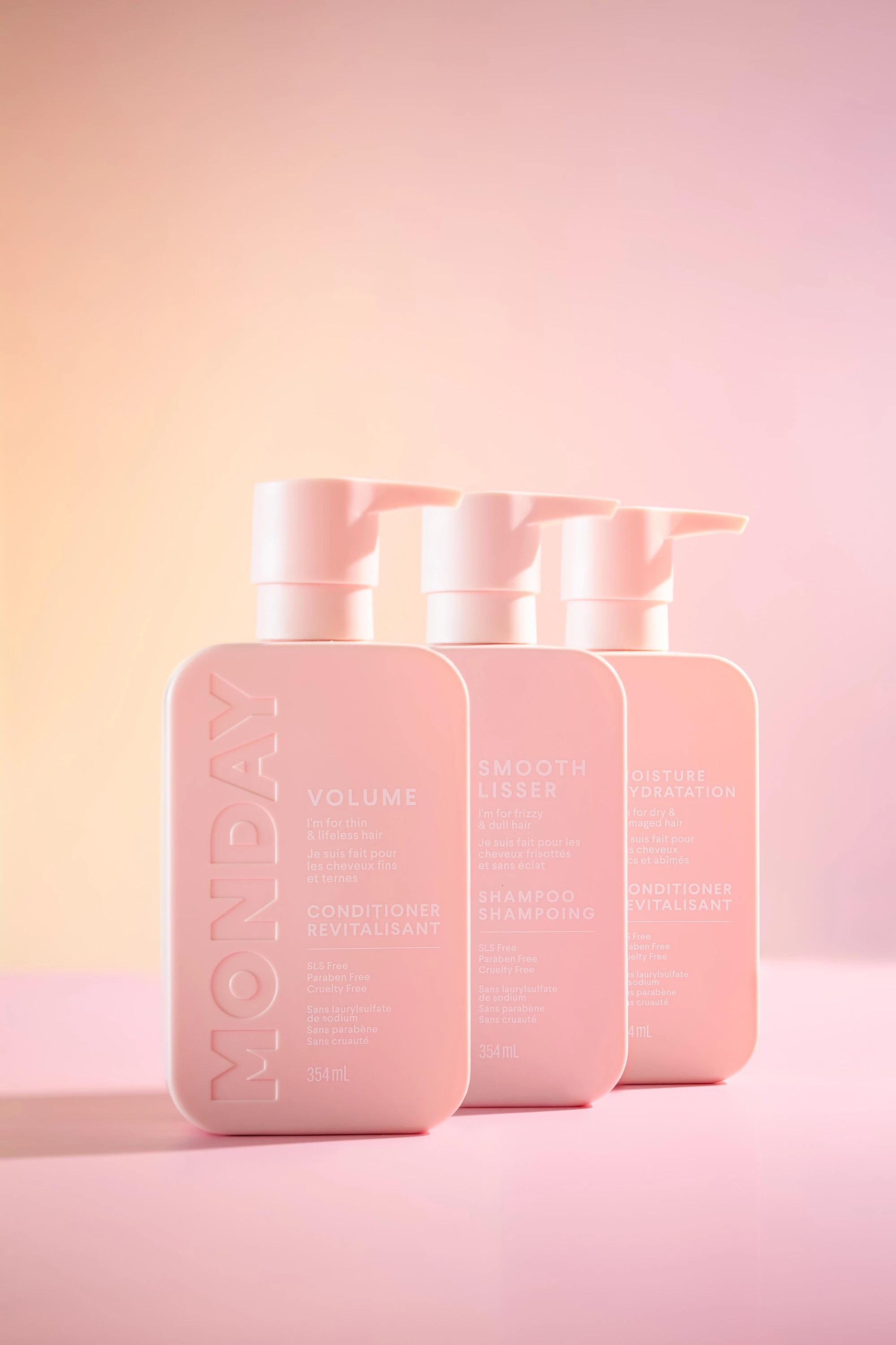 Three bottles of Monday Volume Smooth Lissor on a pink background.