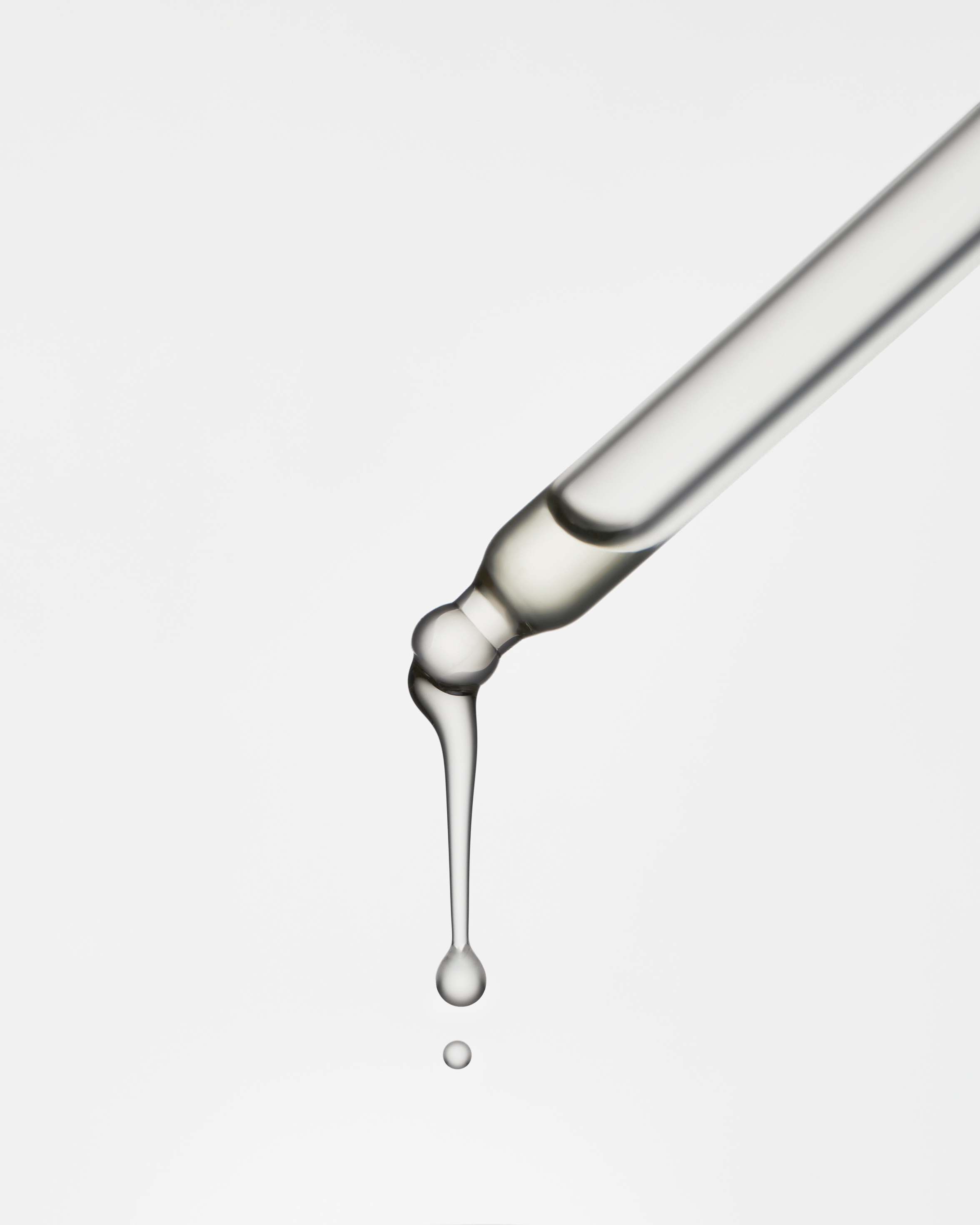 A clear glass tube with a drop of liquid in it.