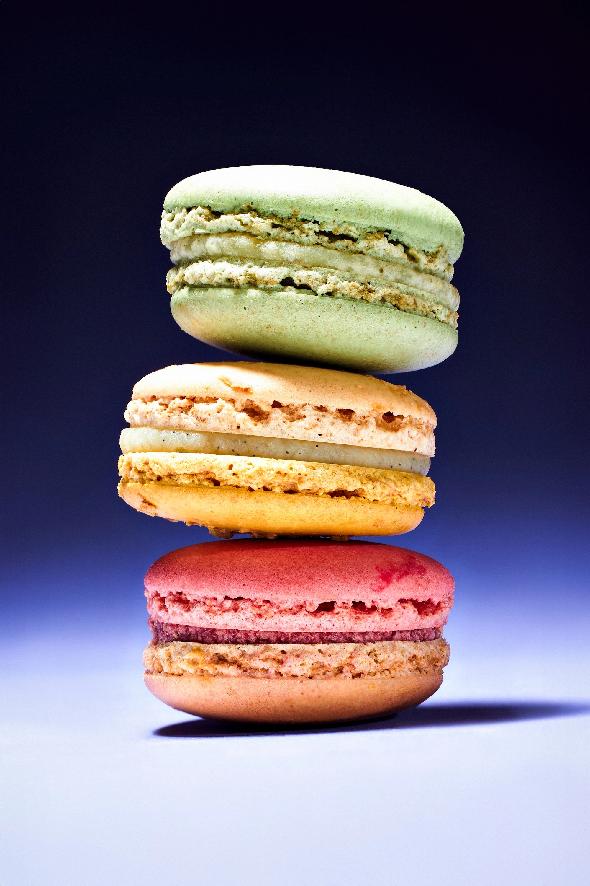 A stack of colorful macaroons with a blue background.