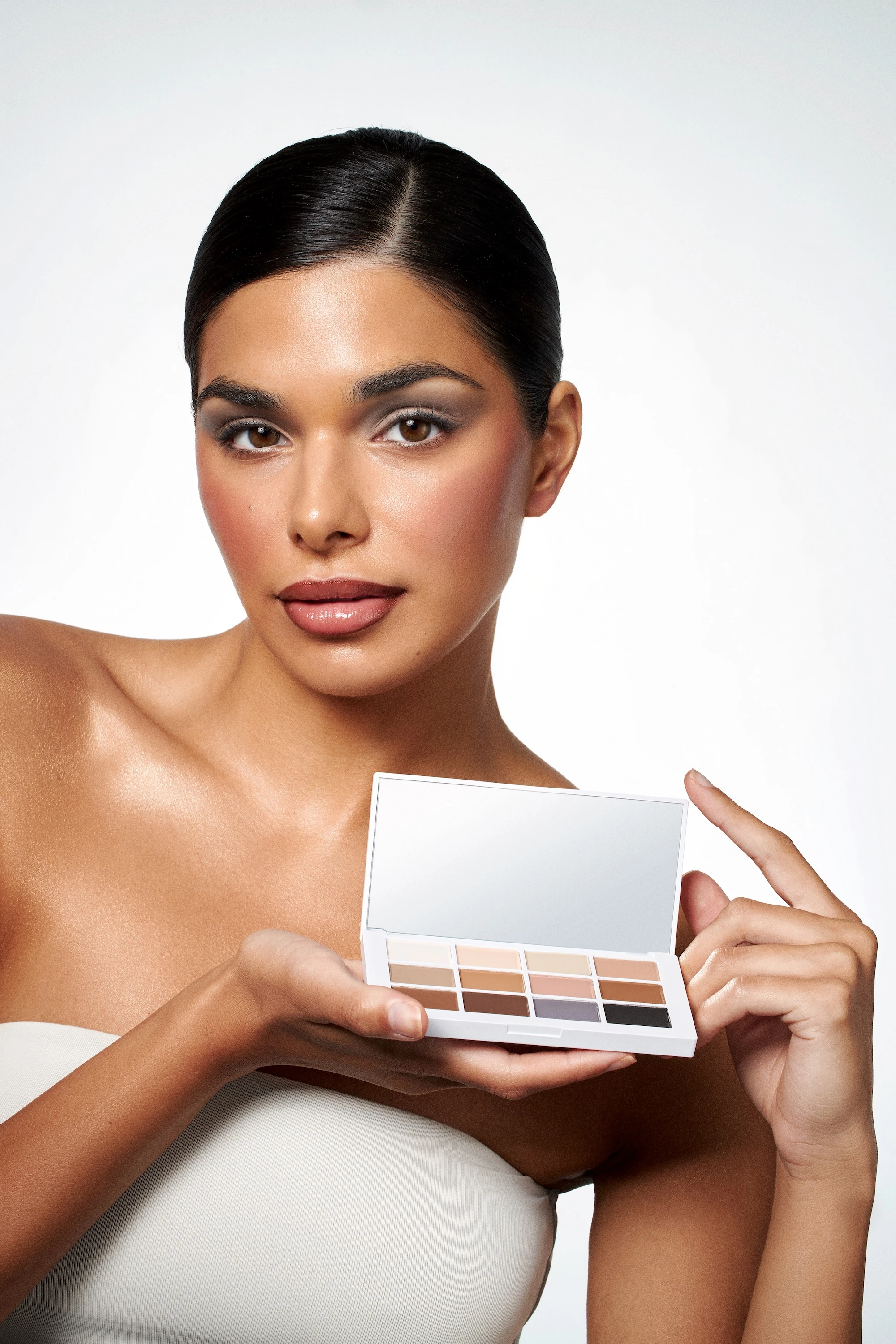 A woman holding a box of makeup by Mario.