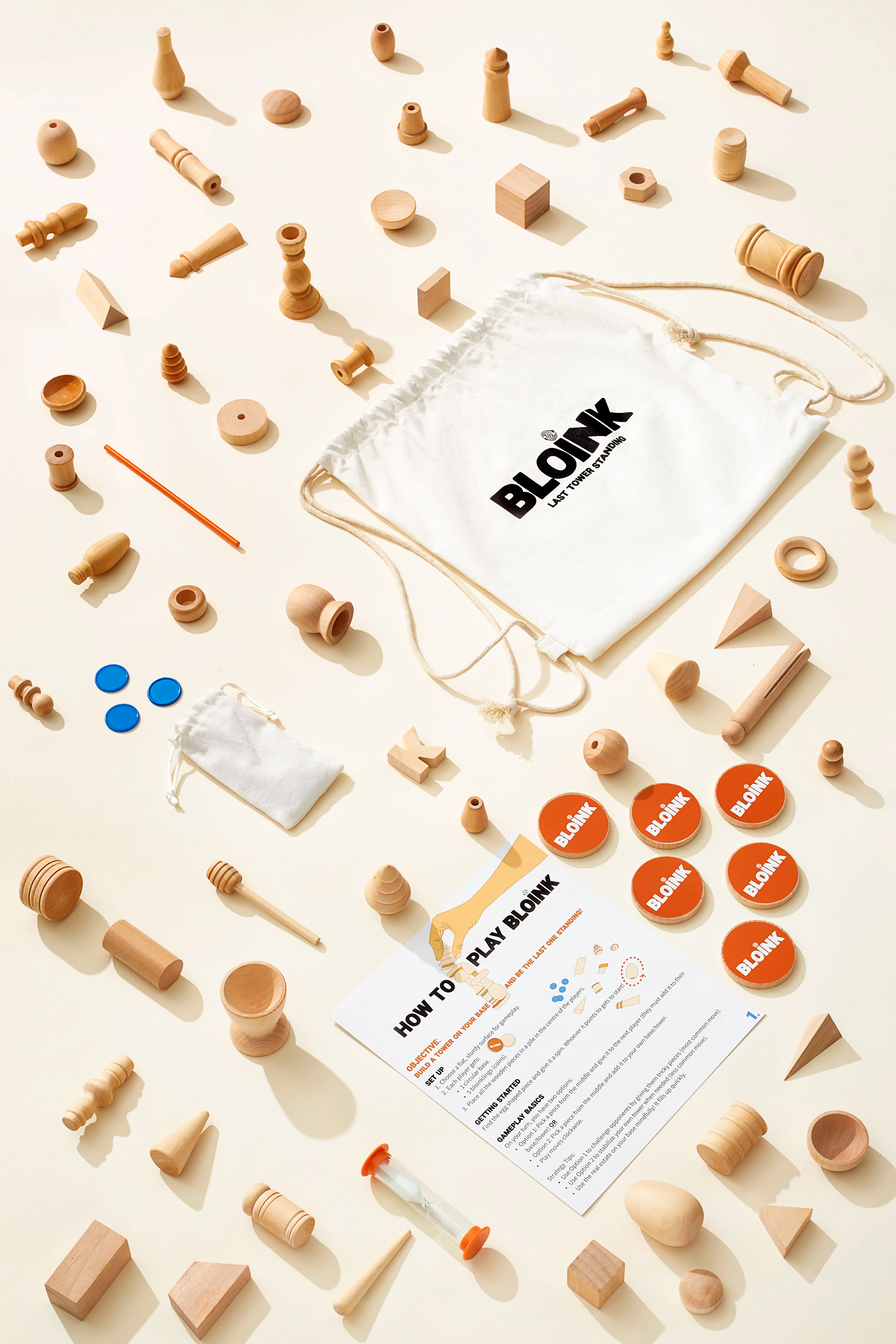A white paper with a black lettered logo and a bag of wooden toys from the Bloink Game