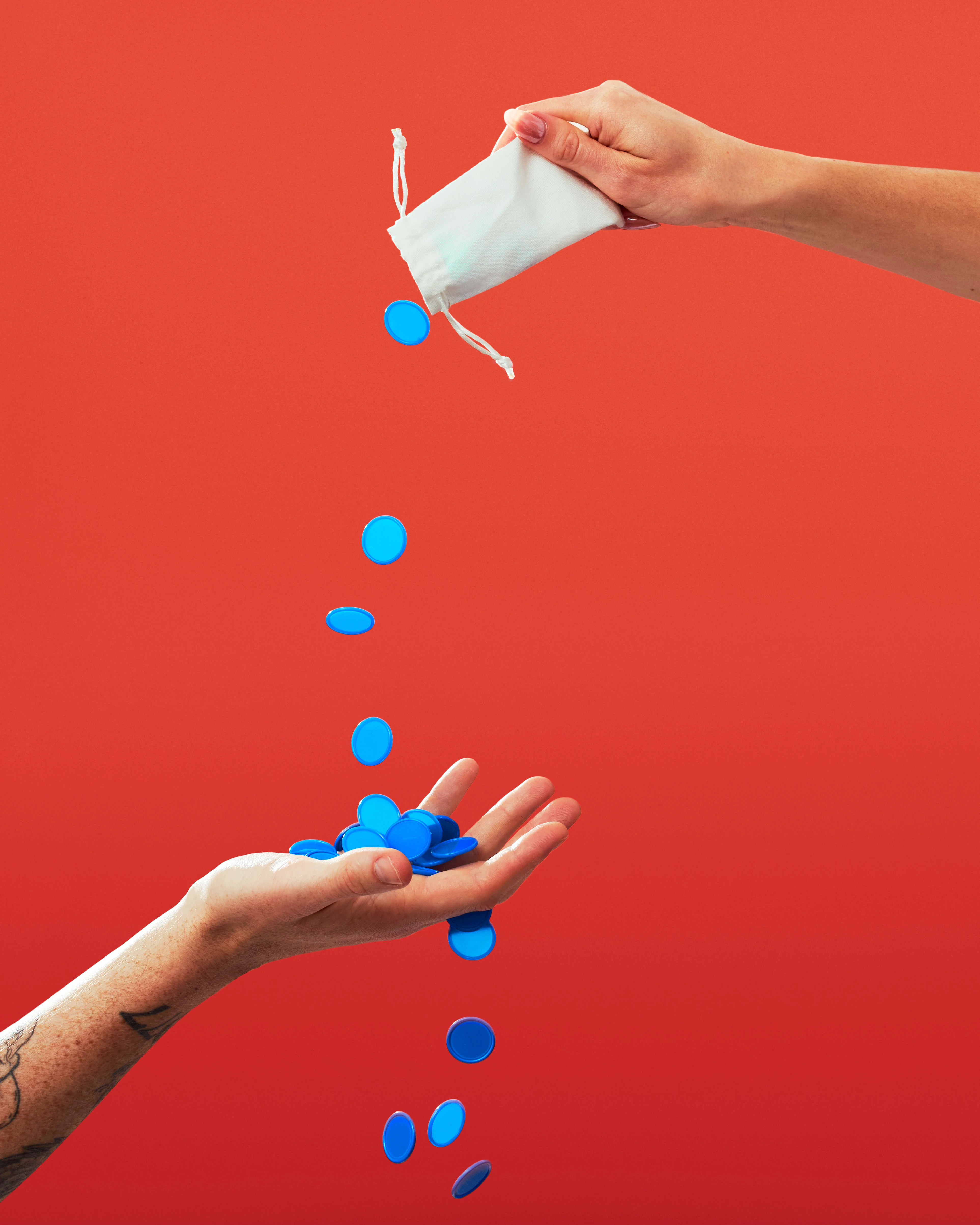A person's hand holding a bag of blue and white balls from the Bloink Game