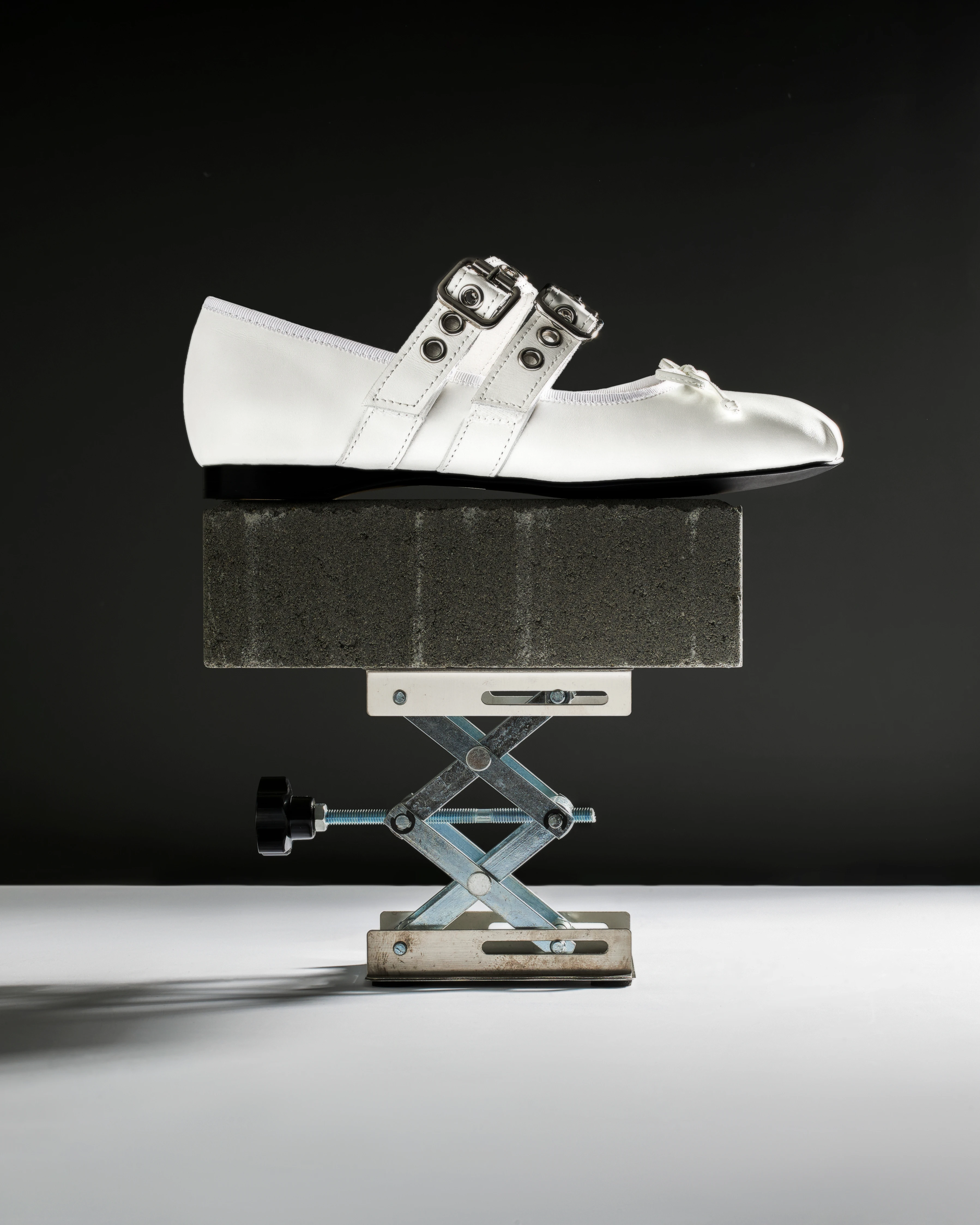 A pair of white shoes on a stand.