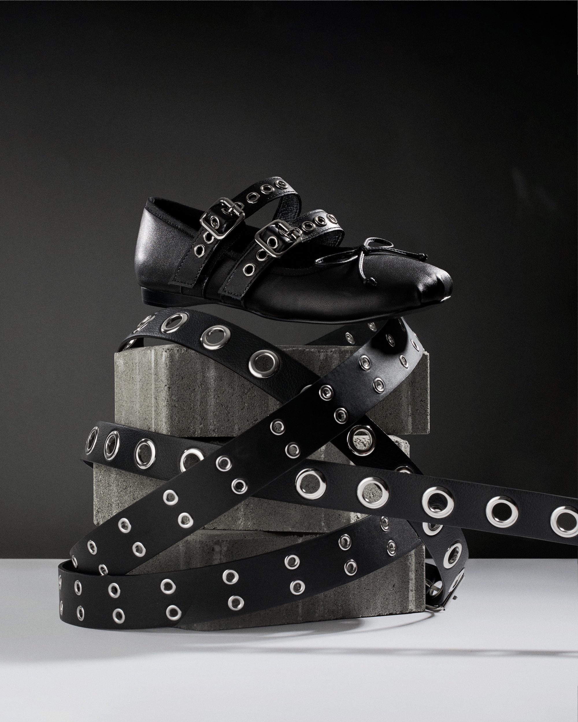 A pair of black shoes with silver studs on the side.