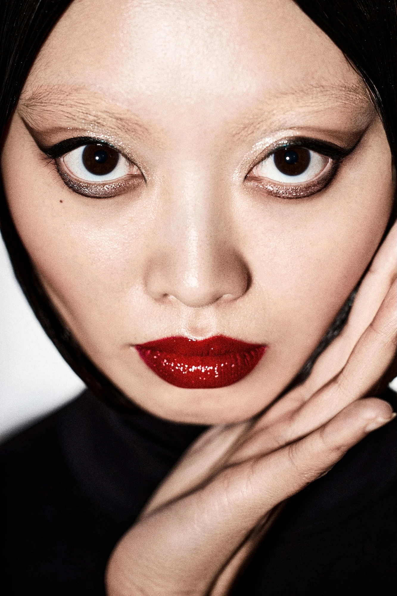 A woman with a black head scarf and red lipstick.