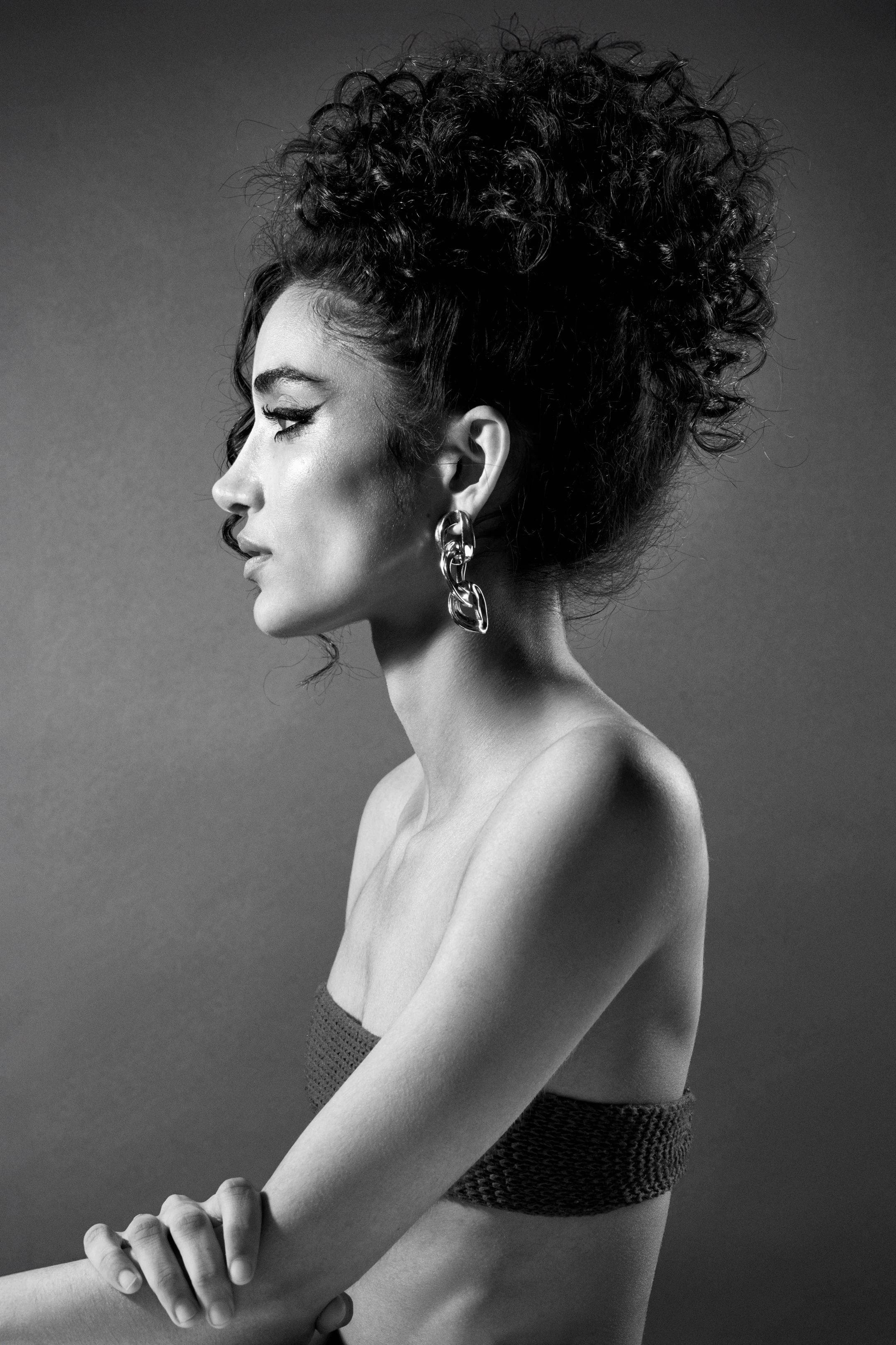 A woman with a nose ring and earrings.