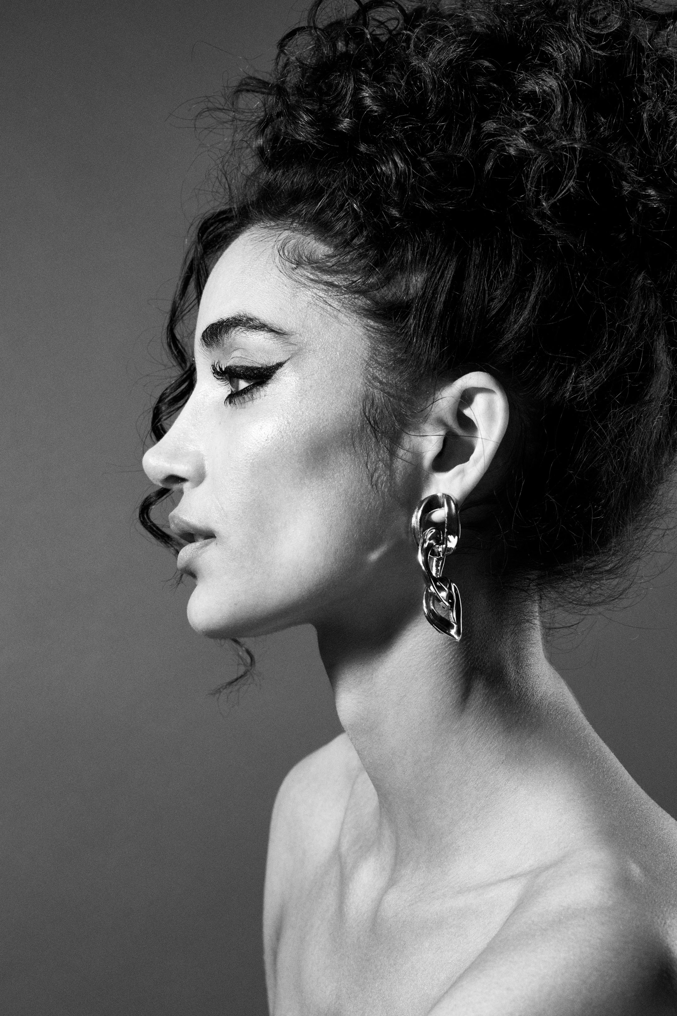 A woman with a nose ring and earrings.
