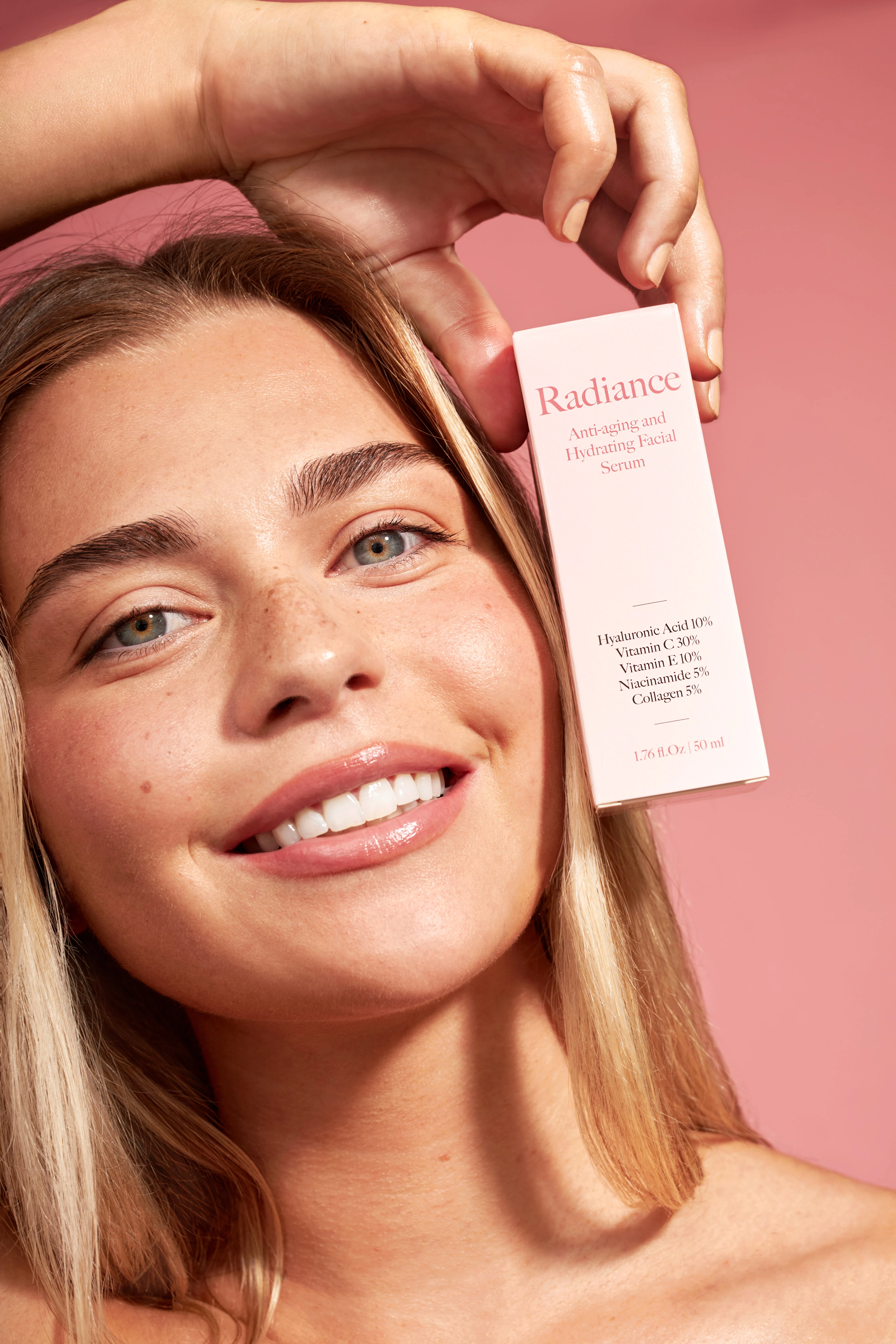 A woman with blonde hair holding a bottle of Radiance.