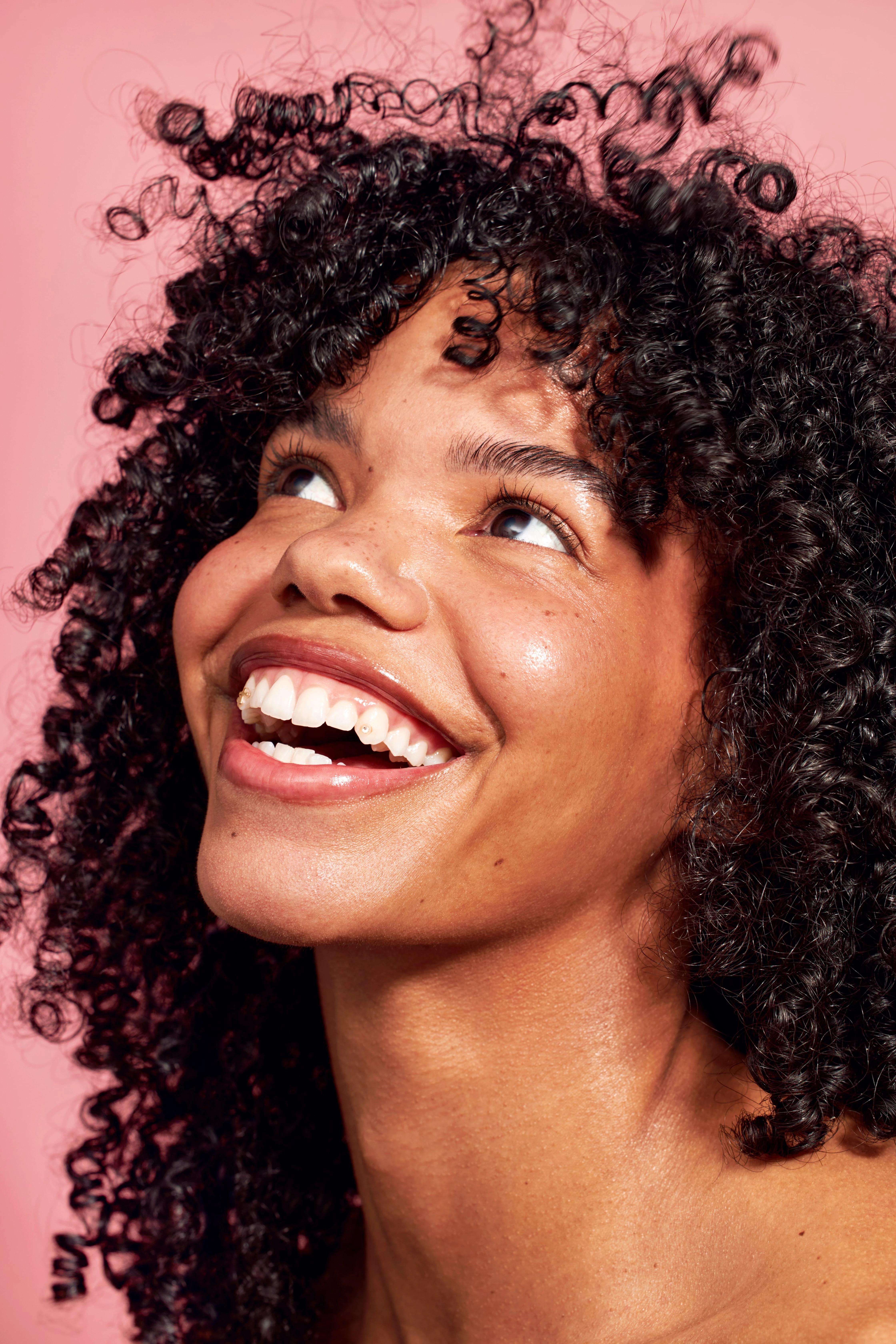 A woman with curly hair and a smile.