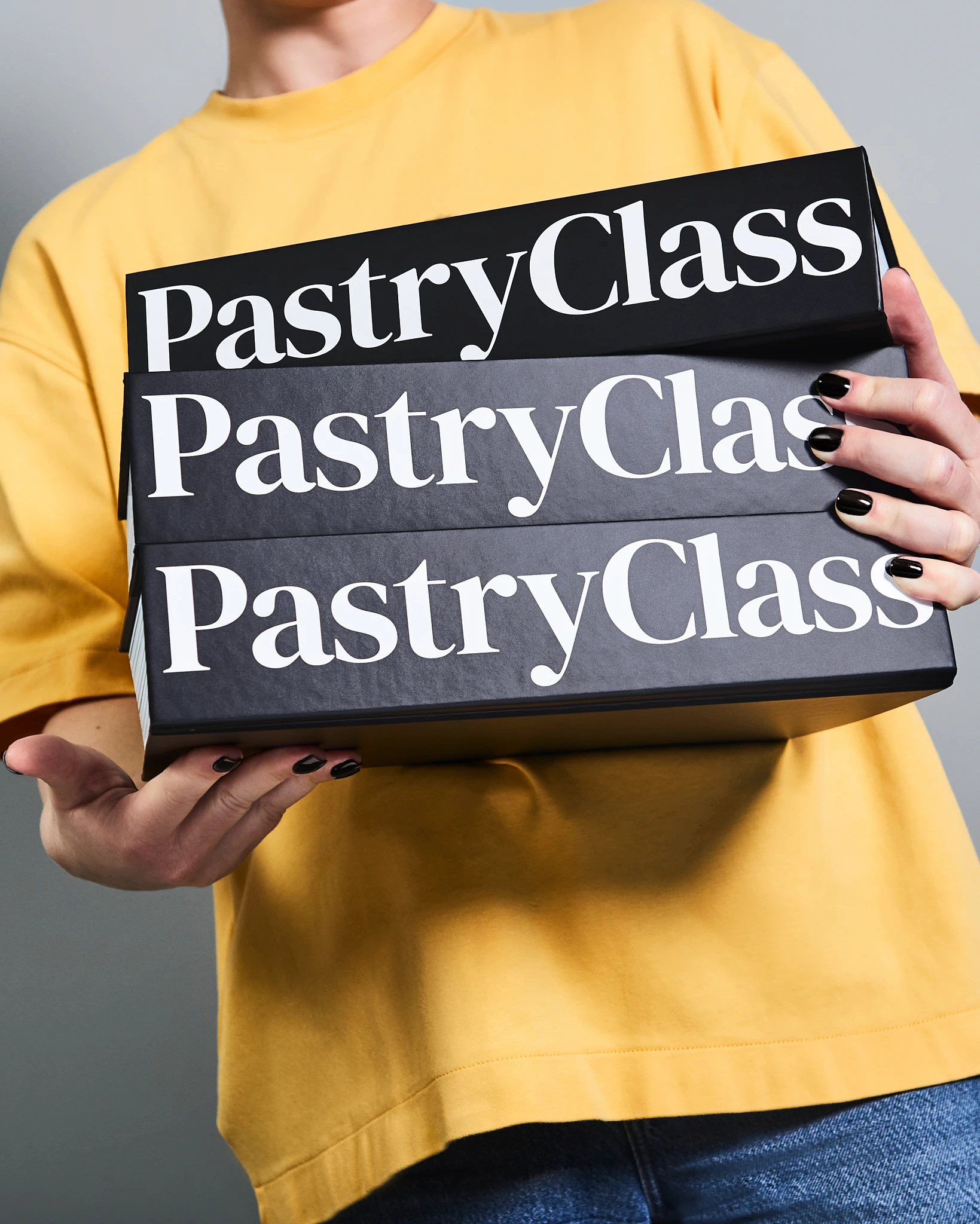 A woman holding a box that says Pastry Class.