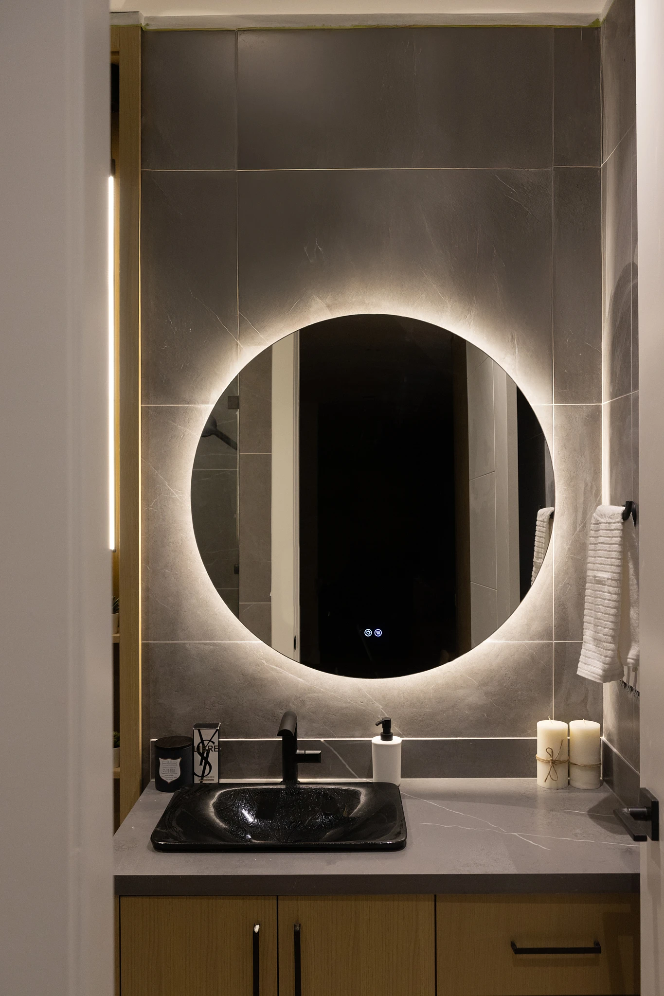 A bathroom with a round mirror and a sink.
